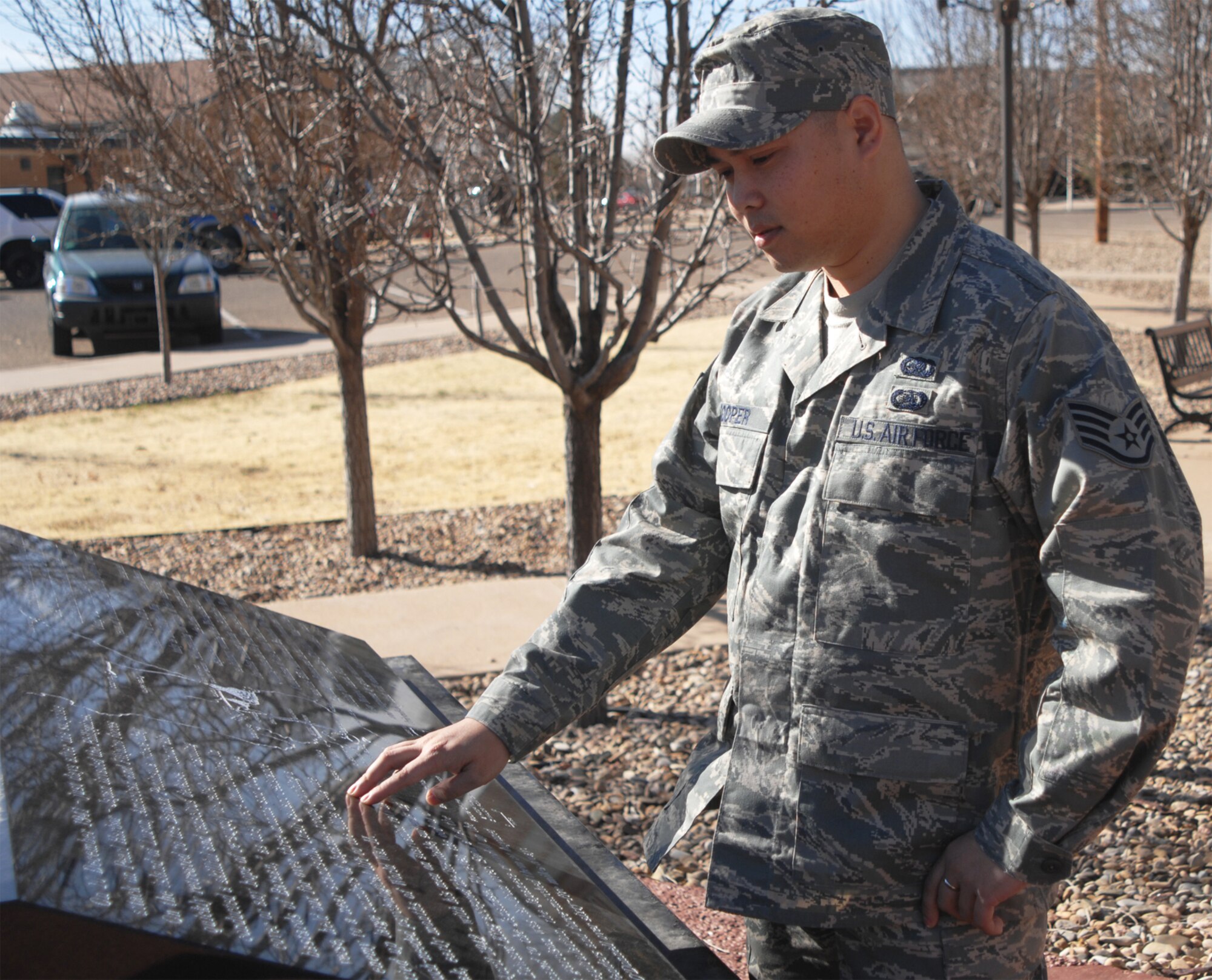 CANNON AIR FORCE BASE, N.M. -- Staff Sgt. Angelito Cooper, 27th Special Operations Logistics Readiness Squadron, reads some of the history of the Bataan Death March at the memorial here. Sergeant Cooper is looking for individuals in the Cannon community to join him in the annual Bataan Memorial Death March on March 30 at White Sands Missile Range near Alamogordo, N.M. Interested individuals can contact him at 784-7741. (Air Force photo by Greg Allen)