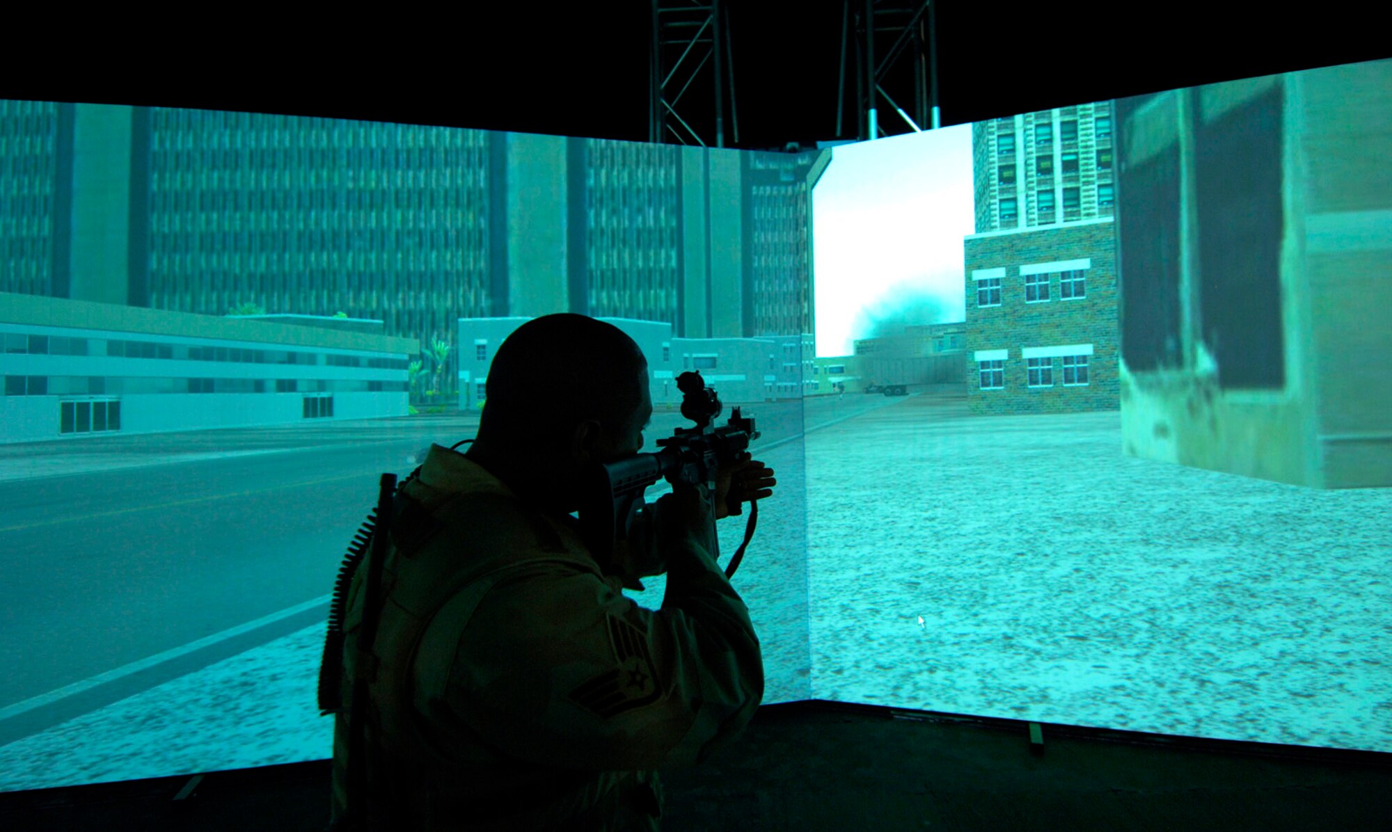 CREECH AIR FORCE BASE, Nev.—Staff Sgt. Bruce Thompson, 99th Ground Combat Training Squadron, integrated base defense instructor, “fires” an M-4 rifle at aggressing forces from a High Mobility Multipurpose Wheeled Vehicle simulator here Feb. 22. The simulator, a first of its kind, will be used to train Airmen in convoy operations and escalation of force tactics. (U.S. Air Force photo by Master Sgt. Kevin J. Gruenwald)