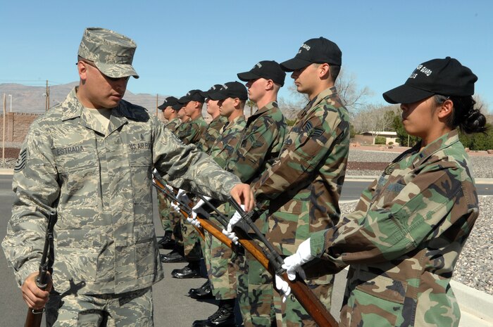 NELLIS AIR FORCE BASE, Nev.—Tech. Sgt. Jason Estrada (left), U.S. Air Force Honor Guard program noncommissioned officer in charge, instructs members of the Nellis AFB Honor Guard on the proper way to carry a weapon during a firing party, here Feb. 25. The Air Force Honor Guard Drill Team is here as part of a mobile unit designed to help local honor guards standardize drill and ceremony techniques across the Air Force. This is the team’s first visit back for this purpose since 2005. (U.S. Air Force photo by Senior Airman Nadine Y. Barclay)