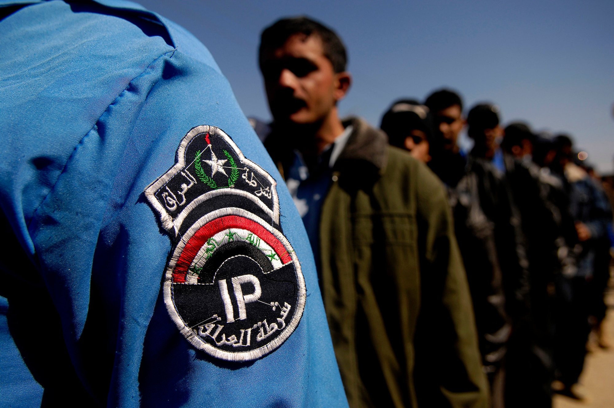Iraqi police officers line up to be entered into a database by a handheld interagency identity detection equipment Feb. 23 at Rasheed, Iraq. American Airmen from Det. 3 732nd Expeditionary Security Forces Squadron from Sather Air Base, Iraq, conducted the security screening. (U.S. Air Force photo/Master Sgt. Andy Dunaway)