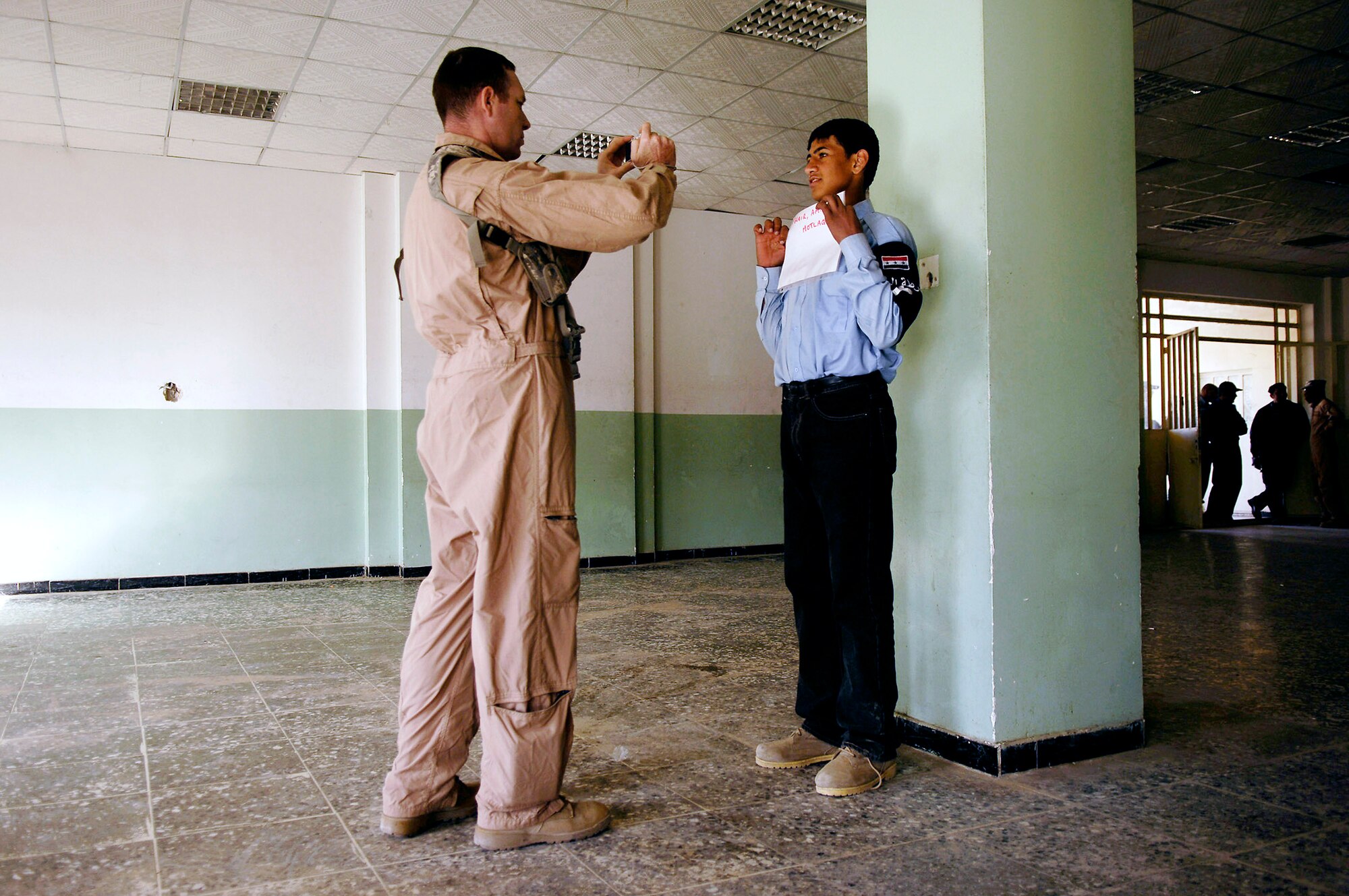 Tech. Sgt. Justin Duncan photographs an Iraqi police officer to be entered into a database Feb. 23 at Rasheed, Iraq. Sergeant Duncan is assigned to Det. 3, 732nd Expeditionary Security Forces Squadron from Sather Air Base, Iraq, and is deployed from the 341st Security Forces Squadron at Malmstrom Air Force Base, Mont. (U.S. Air Force photo/Master Sgt. Andy Dunaway) 