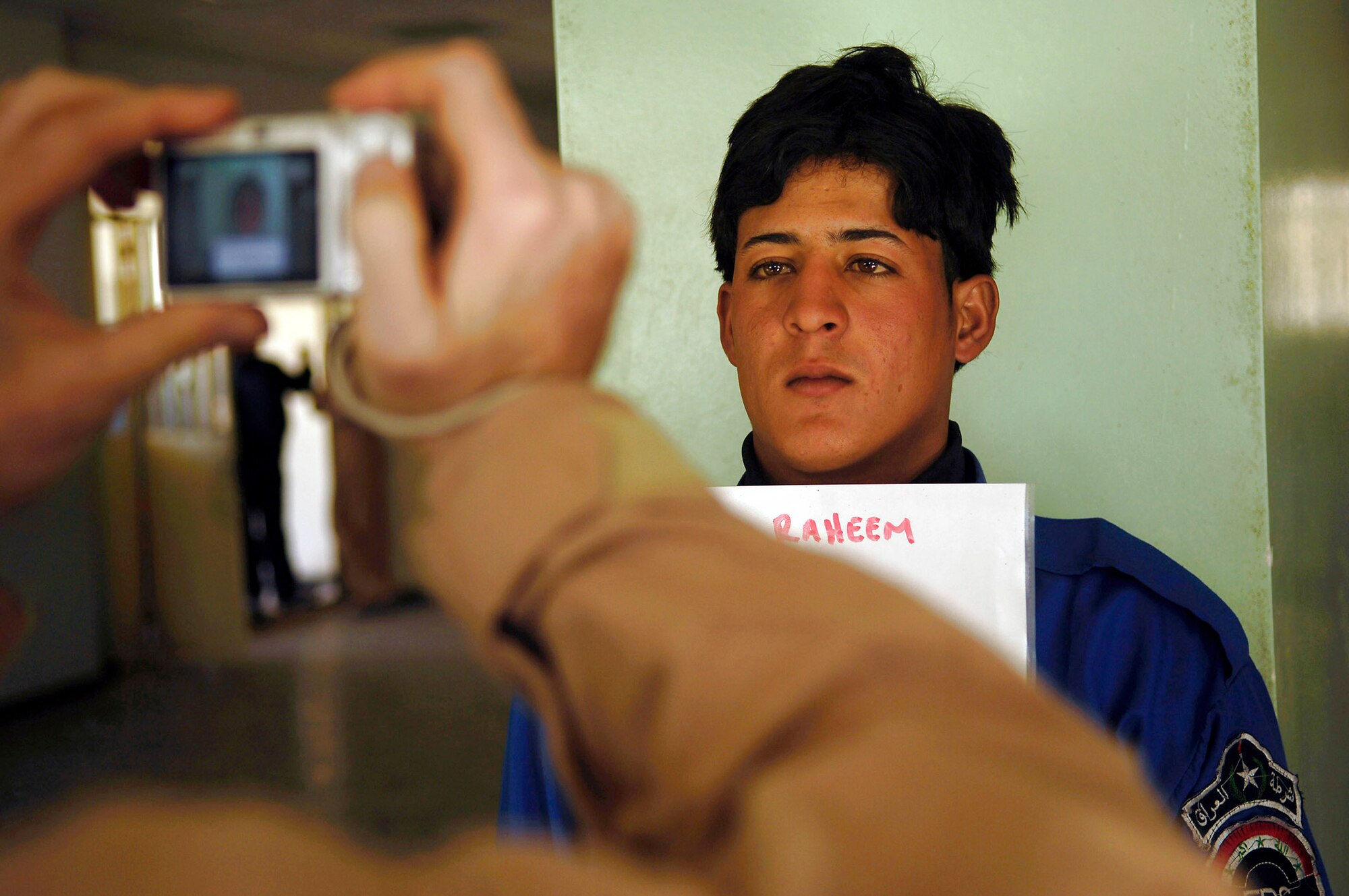 Tech. Sgt. Justin Duncan photographs an Iraqi police officer to be entered into a database Feb. 23 at Rasheed, Iraq. Sergeant Duncan is assigned to Det. 3, 732nd Expeditionary Security Forces Squadron from Sather Air Base, Iraq, and is deployed from the 341st Security Forces Squadron at Malmstrom Air Force Base, Mont. (U.S. Air Force photo/Master Sgt. Andy Dunaway) 