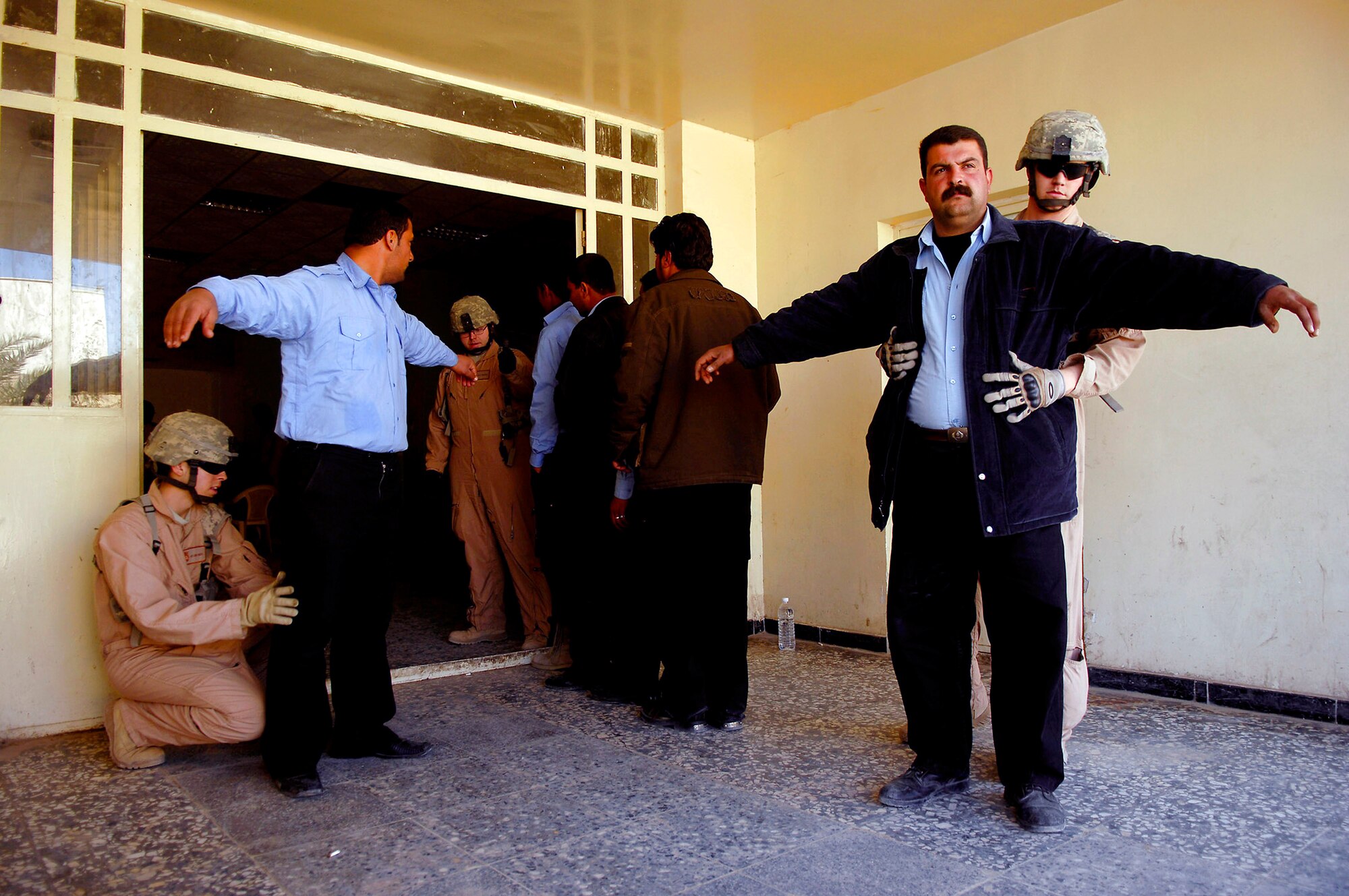 Security forces Airmen conduct a search of Iraqi police officers prior granting access into the database by the handheld interagency identity detection equipment Feb. 23 at Rasheed, Iraq. Security forces Airmen are assigned to Det. 3, 732nd Expeditionary Security Forces Squadron from Sather Air Base, Iraq. (U.S. Air Force photo/Master Sgt. Andy Dunaway) 