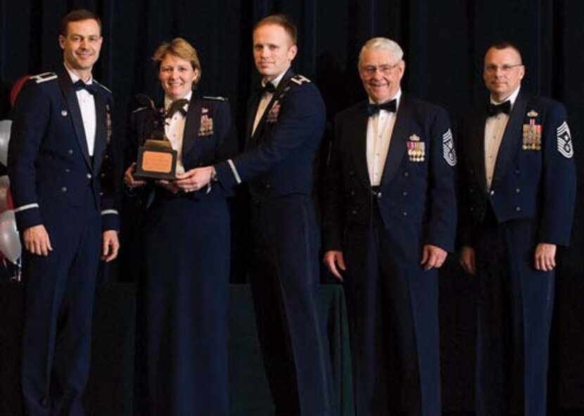 Col. Steven Harrison, 436th Airlift Wing commander, representatives for Master Sgt. Jeffrey Hurley, 436th Civil Engineer Squadron, retired Chief Master Sgt. Robert Gaylor, the fifth Chief Master Sgt. of the Air Force, and Chief Master Sgt. John Wood, 436th AW command chief, assemble on stage at the 436th Airlift Wing’s 2007 Annual Awards Banquet as Sergeant Hurley’s representatives are presented his trophy. Sergeant Hurley was named the Senior NCO of the Year, 2007. (U.S. Air Force photo/Roland Balik)
