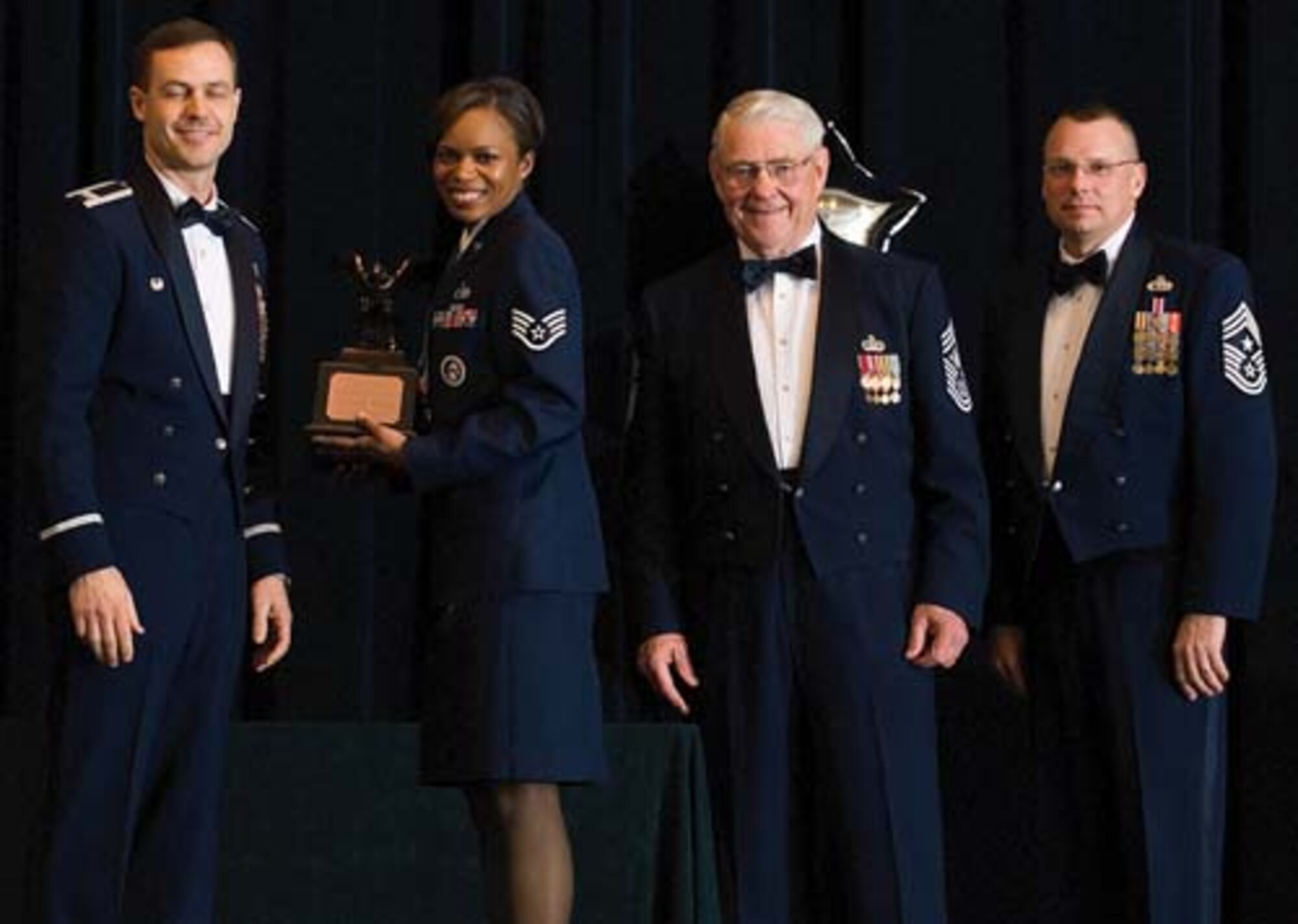 Col. Steven Harrison, 436th Airlift Wing commander, Staff Sgt. Lennell Deloatch, 436th Logistics Readiness Squadron, retired Chief Master Sgt. Robert Gaylor, the fifth Chief Master Sgt. of the Air Force, and Chief Master Sgt. John Wood, 436th AW command chief, assemble on stage at the 436th Airlift Wing’s 2007 Annual Awards Banquet as Sergeant Deloatch is presented her trophy. Sergeant Deloach was named the Honor Guard Member of the Year, 2007. (U.S. Air Force photo/Roland Balik)