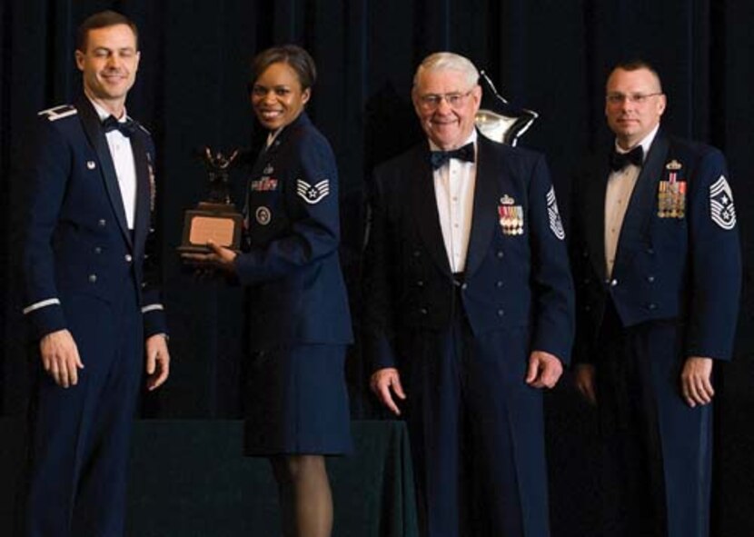 Col. Steven Harrison, 436th Airlift Wing commander, Staff Sgt. Lennell Deloatch, 436th Logistics Readiness Squadron, retired Chief Master Sgt. Robert Gaylor, the fifth Chief Master Sgt. of the Air Force, and Chief Master Sgt. John Wood, 436th AW command chief, assemble on stage at the 436th Airlift Wing’s 2007 Annual Awards Banquet as Sergeant Deloatch is presented her trophy. Sergeant Deloach was named the Honor Guard Member of the Year, 2007. (U.S. Air Force photo/Roland Balik)