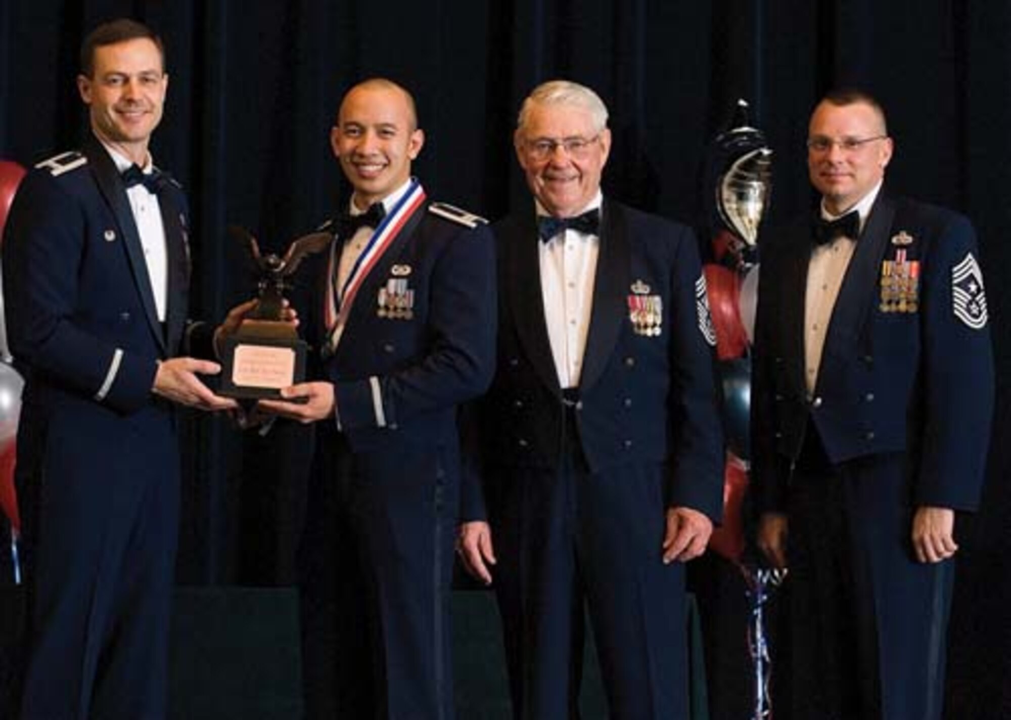 Col. Steven Harrison, 436th Airlift Wing commander, Capt. Quoc-Nam Nguyen, 436th Contracting Squadron, retired Chief Master Sgt. Robert Gaylor, the fifth Chief Master Sgt. of the Air Force, and Chief Master Sgt. John Wood, 436th AW command chief, assemble on stage at the 436th Airlift Wing’s 2007 Annual Awards Banquet as Captain Nguyen is presented his trophy. Captain Nguyen was named the Company Grade Officer of the Year, 2007. (U.S. Air Force photo/Roland Balik)
