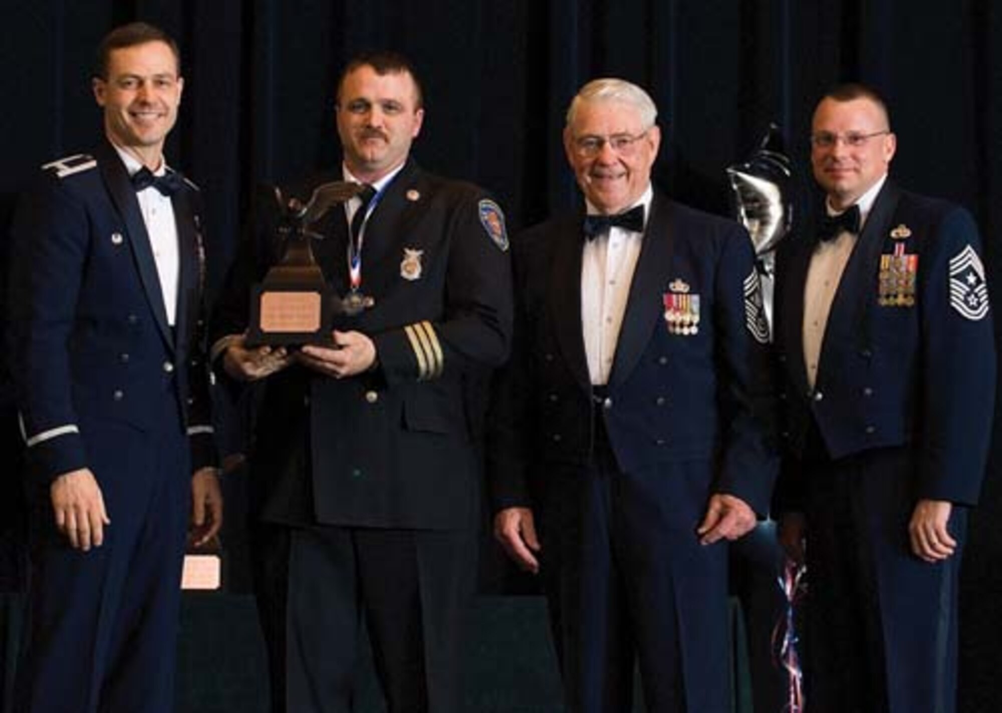 Col. Steven Harrison, 436th Airlift Wing commander, Brian Cullen, 436th Civil Engineer Squadron, retired Chief Master Sgt. Robert Gaylor, the fifth Chief Master Sgt. of the Air Force, and Chief Master Sgt. John Wood, 436th AW command chief, assemble on stage at the 436th Airlift Wing’s 2007 Annual Awards Banquet as Mr. Cullen is presented his trophy. Mr. Cullen was named the Civilian of the Year, Category II, 2007. (U.S. Air Force photo/Roland Balik)