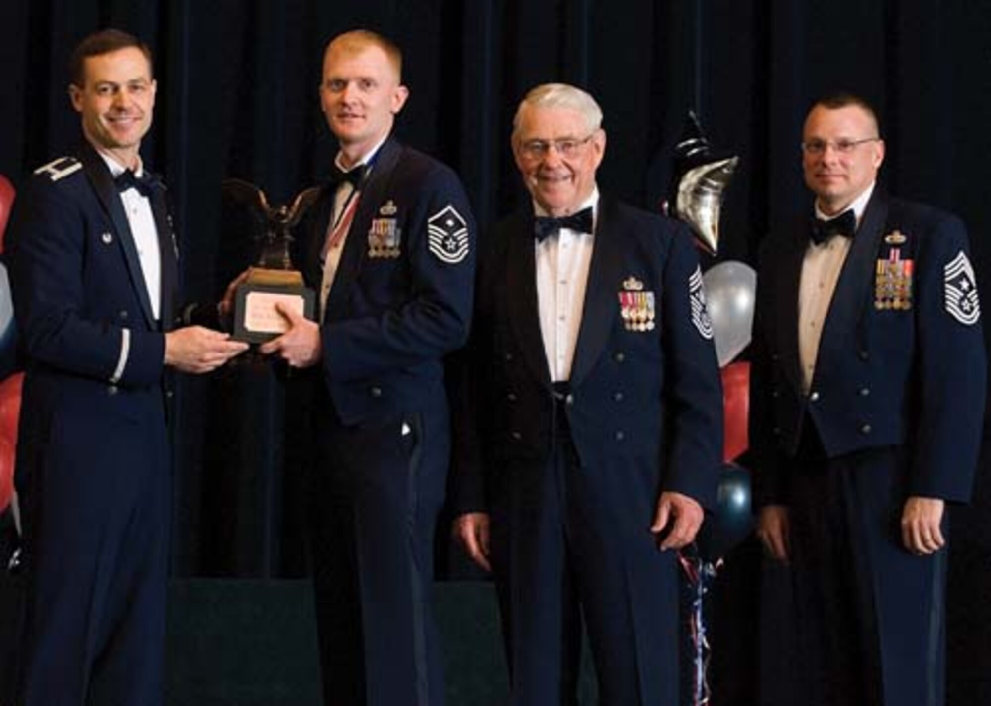 Col. Steven Harrison, 436th Airlift Wing commander, Master Sgt. Kevin Craig, 9th Airlift Squadron, retired Chief Master Sgt. Robert Gaylor, the fifth Chief Master Sgt. of the Air Force, and Chief Master Sgt. John Wood, 436th AW command chief, assemble on stage at the 436th Airlift Wing’s 2007 Annual Awards Banquet as Sergeant Craig is presented his trophy. Sergeant Craig was named the First Sergeant of the Year, 2007. (U.S. Air Force photo/Roland Balik)