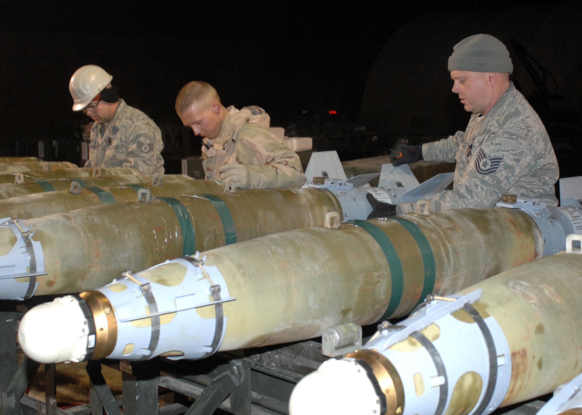 Munitions troops with the 455th Expeditionary Maintenance Squadron assemble guided bomb unit-38 bombs during the night shift Feb 14 at Bagram Air Base, Afghanistan. The bombs will be loaded onto F-15 Strike Eagles for missions in support of the war on terrorism. The Airmen are (left to right) Staff Sgt. Jeremy Woodruff,  Airman 1st Class Zack Demeter and Tech. Sgt. Ben Walker. Sergeant Woodruff is from the 375th Logistic Readiness Squadron, Scott Air Force Base, Ill.,  Airman Demeter is from the 52nd Equipment Maintenance Squadron, Spangdahlem Air Base, Germany, and Sergeant Walker is form the 4th Equipment Maintenance Squadron, Seymour Johnson Air Force Base, N.C. (U.S. Air Force photo/Master Sgt. Demetrius Lester) 