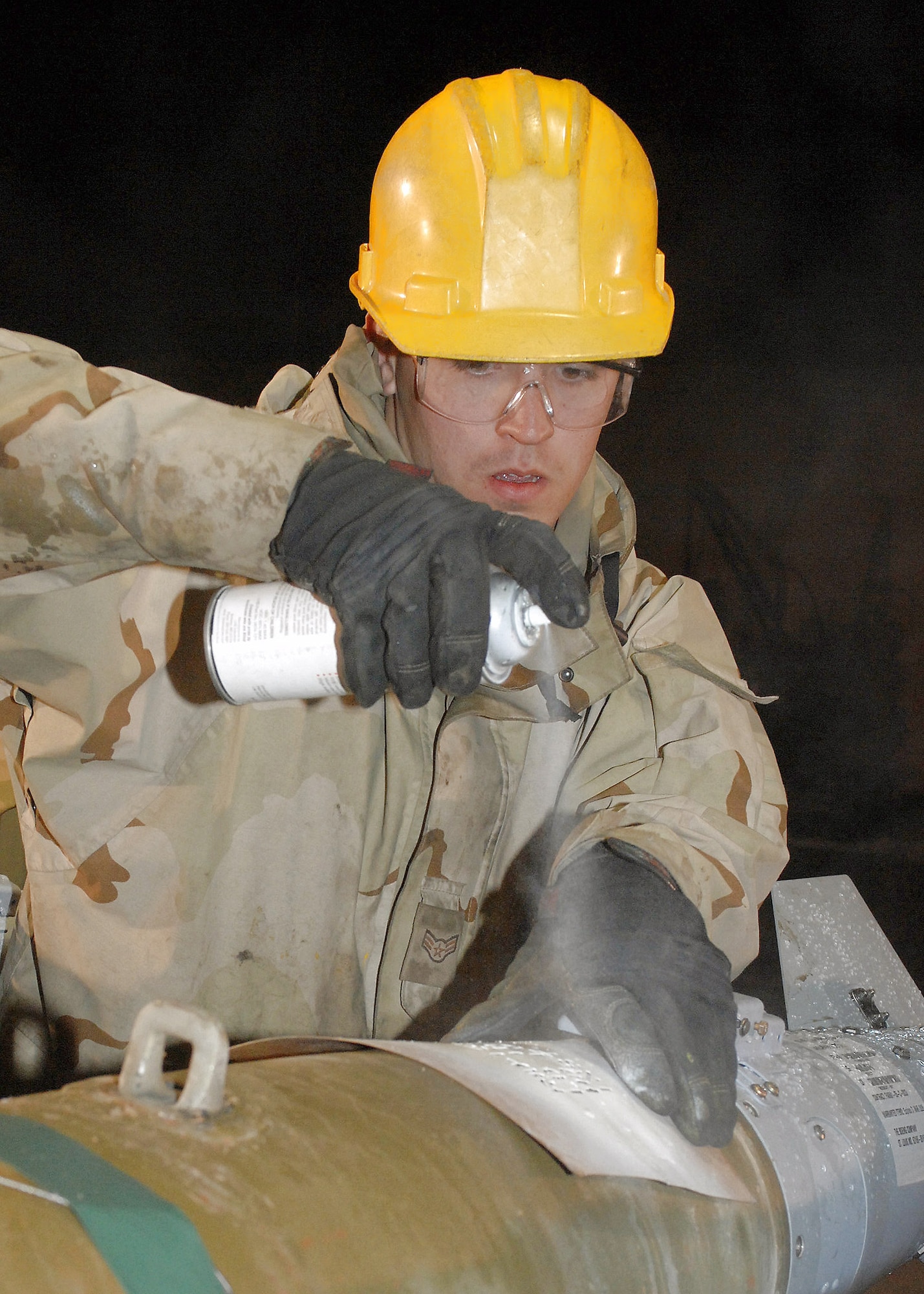 Airman 1st Class Jedediah McClain paints fuse settings on bombs for identification by loaders and pilots Feb 14 at Bagram Air Base, Afghaniston. Airman McClain is a munitons troop with the 455th Expeditionary Maintenance Squadron here and is deployed from the 4th Equipment Maintenance Squadron, Seymour Johnson Air Force Base, N.C. (U.S. Air Force photo/Master Sgt. Demetrius Lester) 