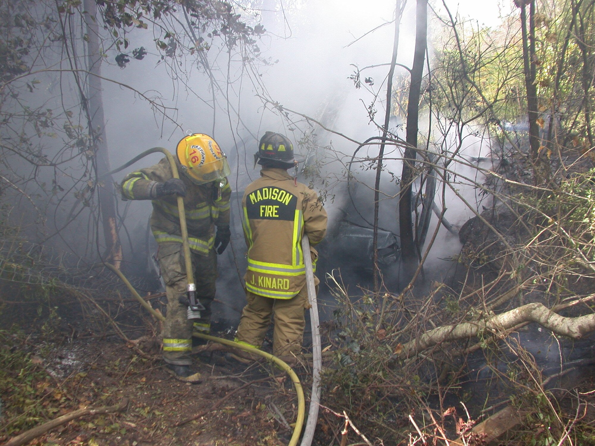 Firefighters try to put the fire after the accident in October.  Airman 1st Class Keith Johnson, 81st Range Control Squadron, helped the people escape the burning car before the explosion.  Photo by Greene Publishing