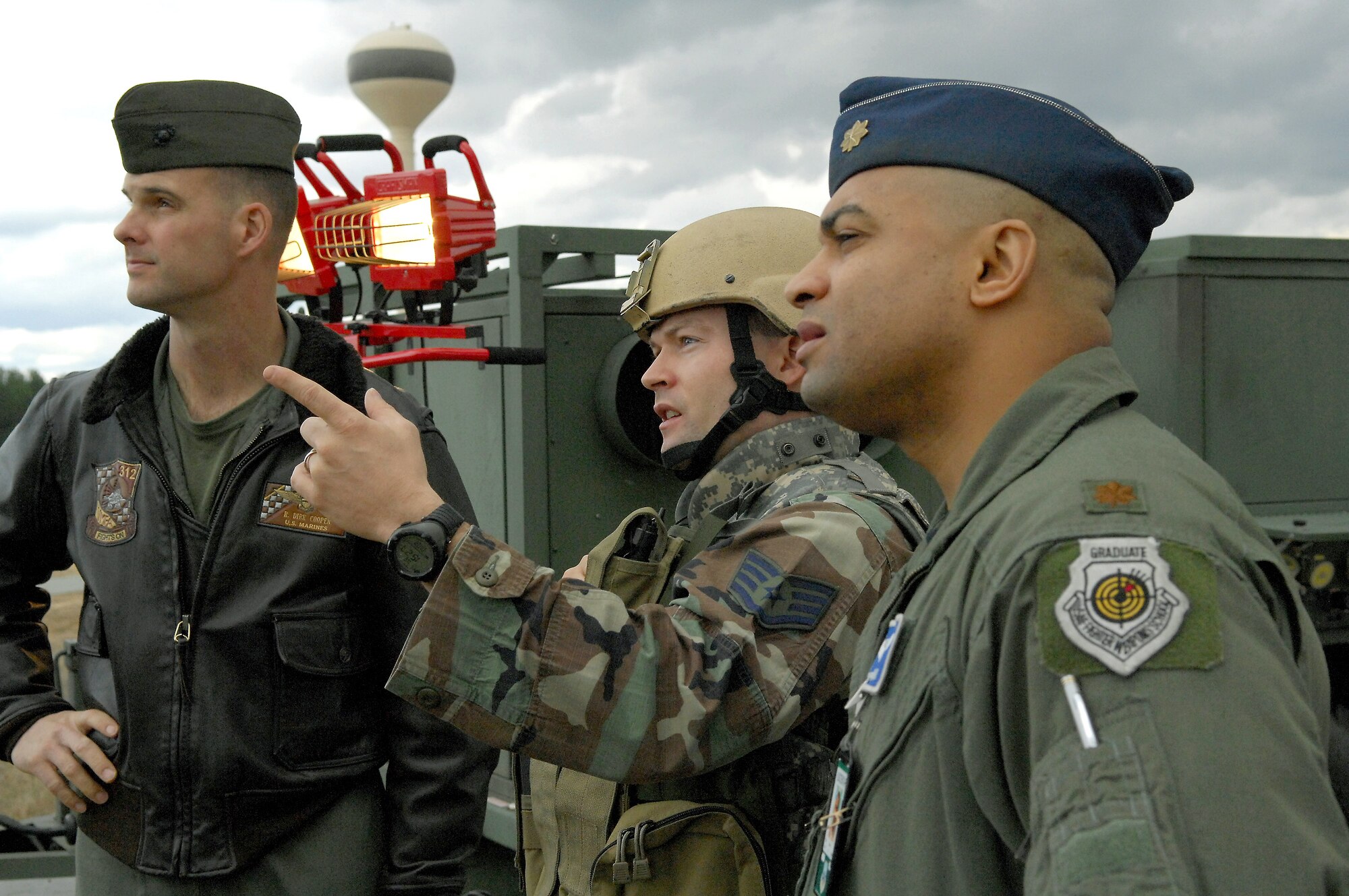 Staff Sgt. Justin Cremer (center) briefs Marine Corps Lt. Col. Robert Cooper (left) and Maj. Darren Gray on the Air Support Operations Center Gateway Feb. 13 at Shaw Air Force Base, S.C. The Gateway, a vehicle mounted communications system, is going through its final tests during an operational readiness exercise before it will be used in theater operations. Sergeant Cremer is the 682nd Air Support Operations Squadron operations training manager, Colonel Cooper is the 609th Combat Operations Squadron U.S. Central Forces weapons officer and Major Gray is the 609th Combat Plans Squadron special assistant to U.S. Central Forces commander. (U.S. Air Force photo/Staff Sgt. Josef  Cole) 