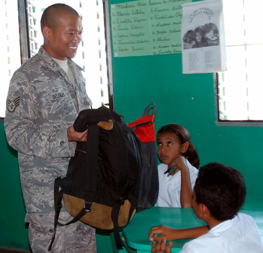 Staff Sgt. Matthew Delgado gives backpacks packed with school supplies to children at a school Feb. 21 in Humuya, Honduras. Five representatives from the Give a Kid a Backpack Organization in Florida and 15 volunteers from Joint Task Force-Bravo from Soto Cano Air Base, Honduras, distributed more than 700 backpacks packed with school supplies to children at five schools and two orphanages in the Comayagua and La Paz districts. Sergeant Delgado is a JTF-Bravo Joint Operations Center controller. (U.S. Air Force photo/Tech. Sgt John Asselin) 