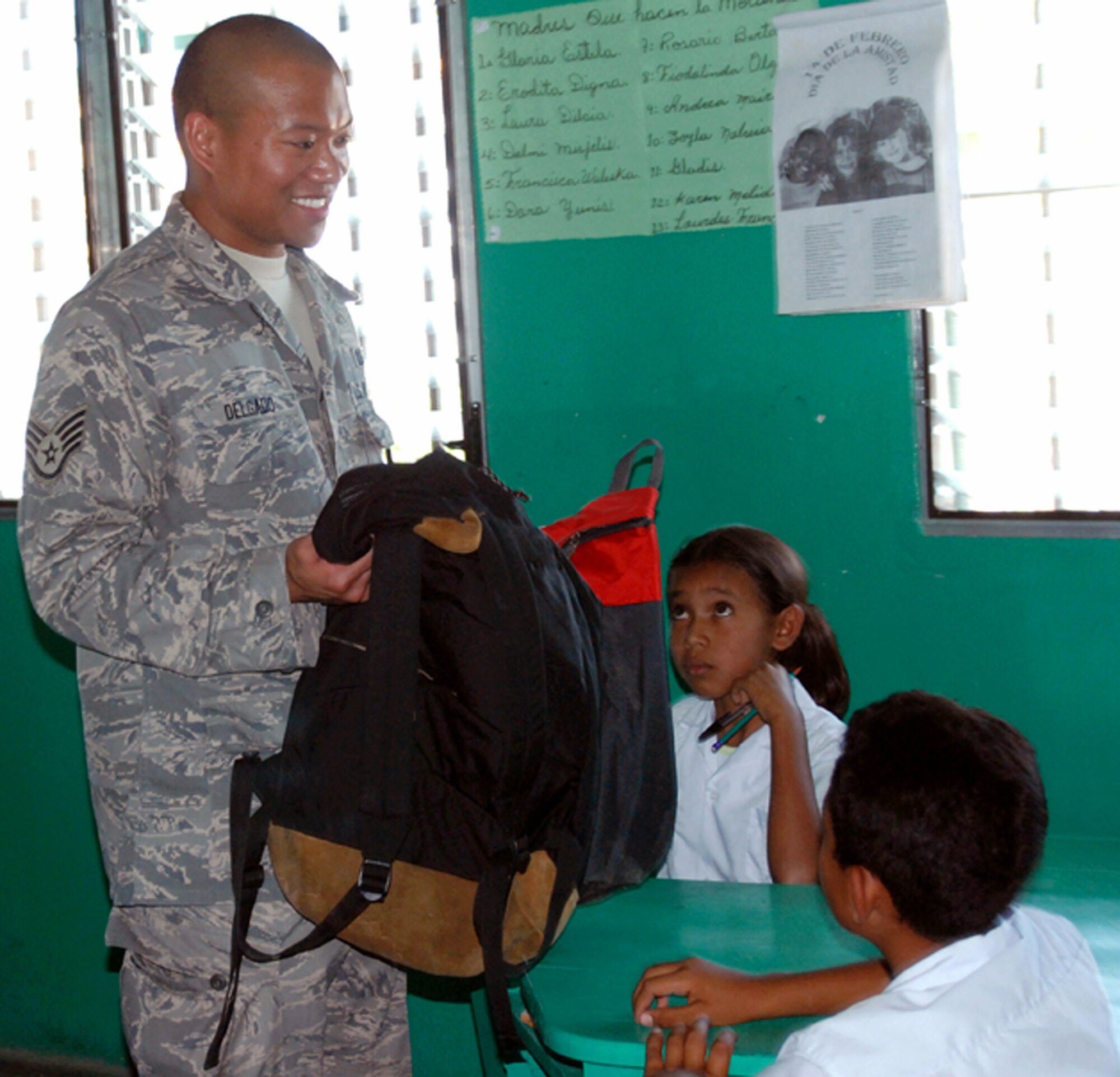 Staff Sgt. Matthew Delgado gives backpacks packed with school supplies to children at a school Feb. 21 in Humuya, Honduras. Five representatives from the Give a Kid a Backpack Organization in Florida and 15 volunteers from Joint Task Force-Bravo from Soto Cano Air Base, Honduras, distributed more than 700 backpacks packed with school supplies to children at five schools and two orphanages in the Comayagua and La Paz districts. Sergeant Delgado is a JTF-Bravo Joint Operations Center controller. (U.S. Air Force photo/Tech. Sgt John Asselin) 
