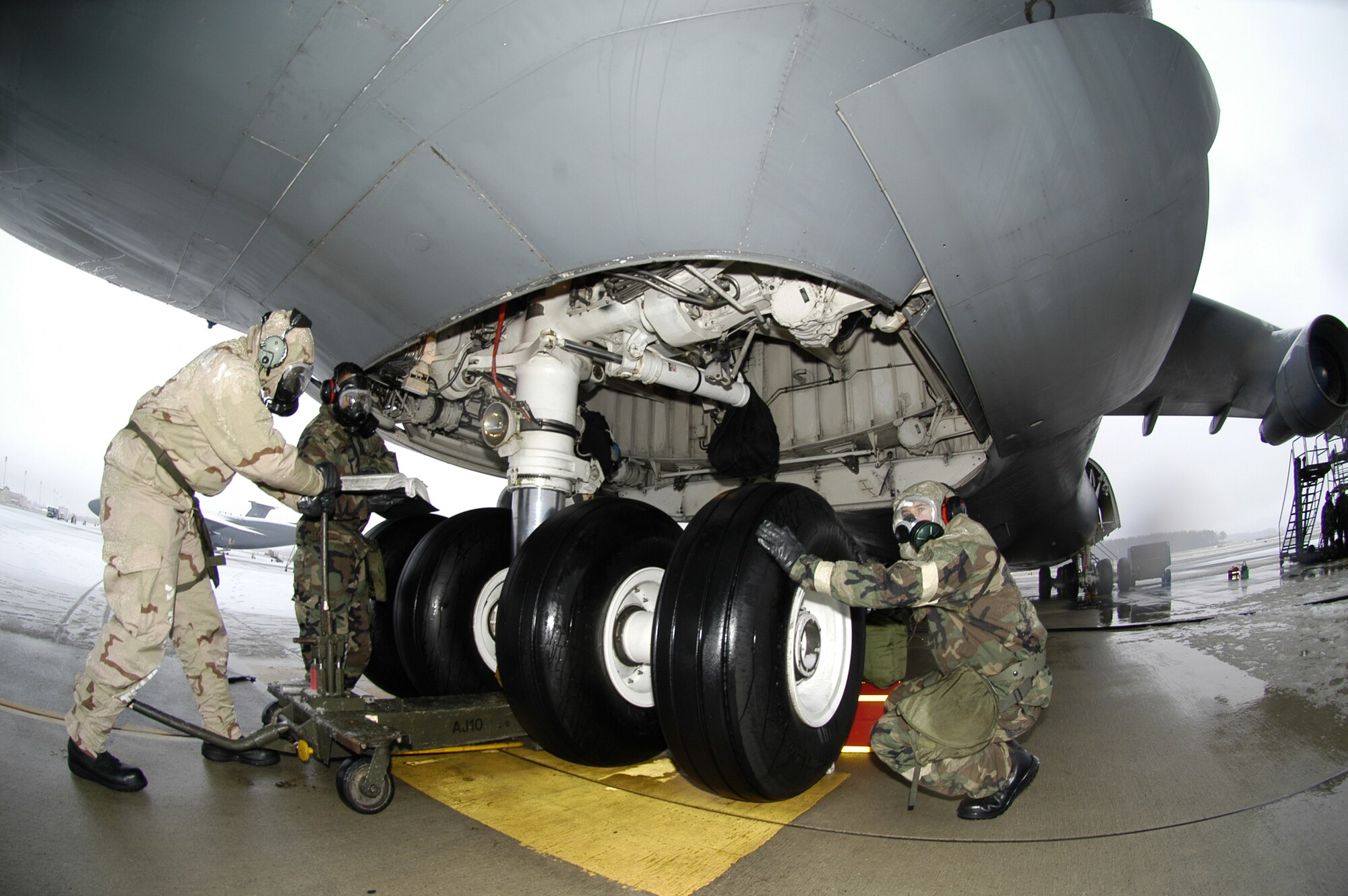 (Left to right) Airman 1st Class George Yarbrough, 436th Maintenance Squadron aero repair technician, Staff Sgt. Carlos Manriquez 436th Aircraft Maintenance Squadron integrated flight control systems technician and Capt. Paul Smith, 436th Maintenance Squadron operations officer change the tires on a C-5 aircraft while working in MOPP gear. The Airmen practiced the ATSO training by performing their mission in mission-oriented-protective-posture gear to prepare themselves for the upcoming Operation Readiness Inspection slated for July. (U.S. Air Force photo/ Airman 1st Class Shen-Chia Chu) 