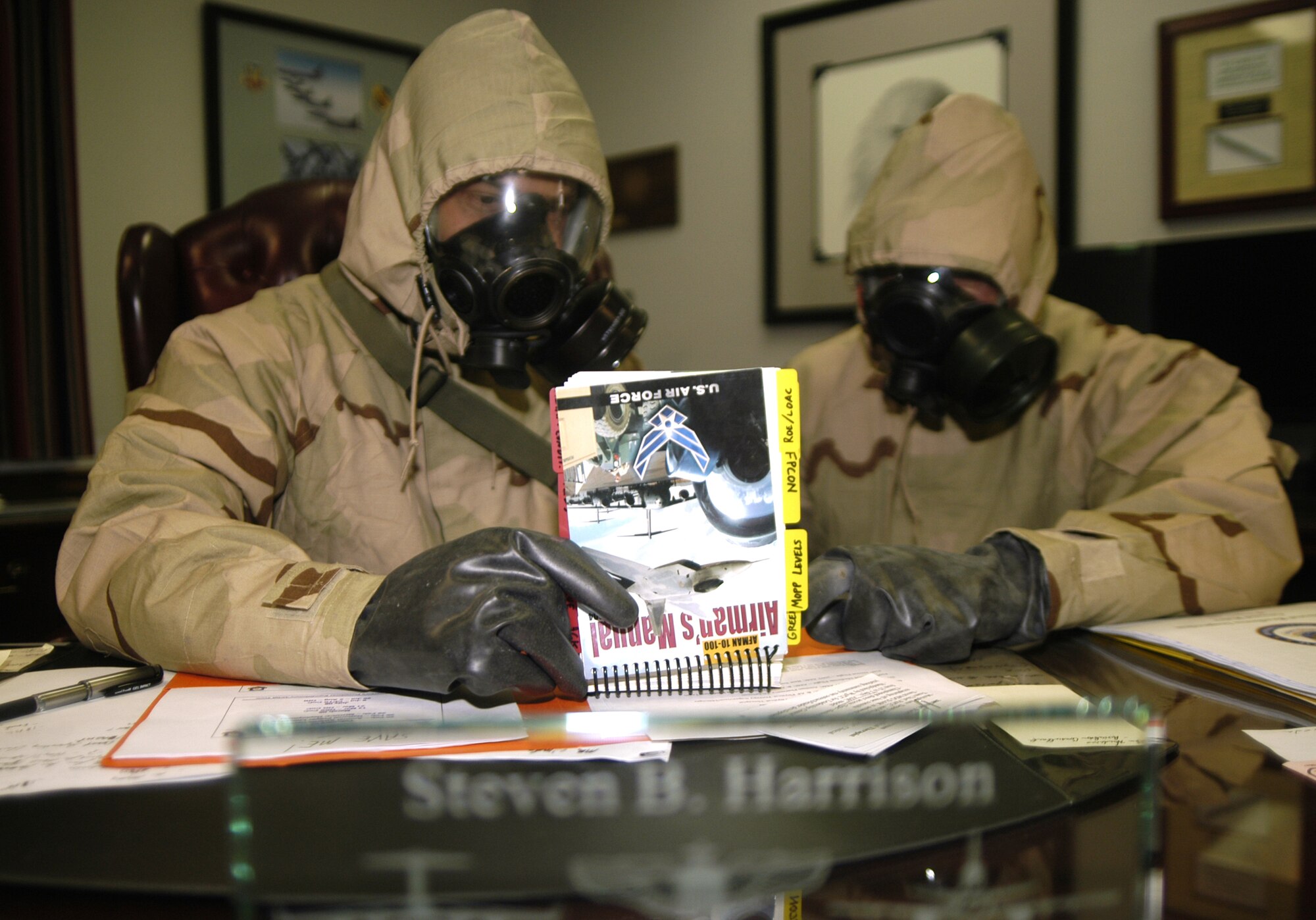 (Left to right) Col. Steve Harrison, 436th Airlift Wing commander and Col. Eric Wydra, 436th AW vice commander, look over a ‘tabbed’ Airman’s Manual in mission-oriented-protective-posture gear during the ATSO training to prepare themselves for the upcoming Operation Readiness Inspection slated for July. The tabs make it easier for Airmen wearing rubber gloves to flip through the Airman’s Manual quicker and find exactly what they’re searching for. (U.S. Air Force photo/ Airman 1st Class Shen-Chia Chu)