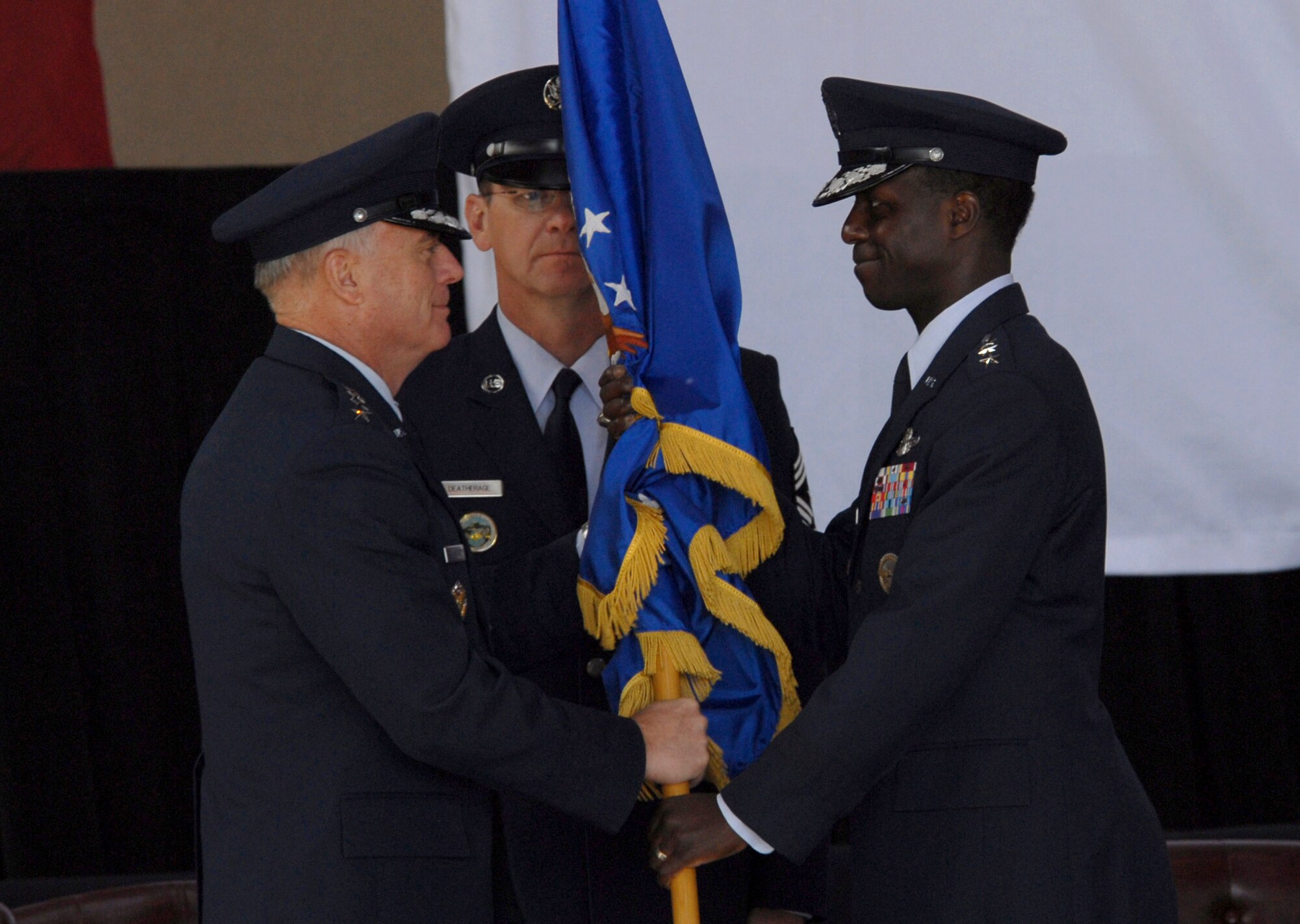 Lt. Gen. Edward A. Rice Jr. accepts the U.S. Forces Japan unit colors from Gen. Carrol H. "Howie" Chandler as Chief Master Sgt. Craig Deatherage looks on Feb. 25 at Yokota Air Base, Japan. General Chandler is the Pacific Air Forces commander from Hickam Air Force Base, Hawaii, and Chief Deatherage is the U.S. Forces Japan and 5th Air Force command chief master sergeant. (U.S. Air Force photo/Senior Airman Brian Kimball) 

