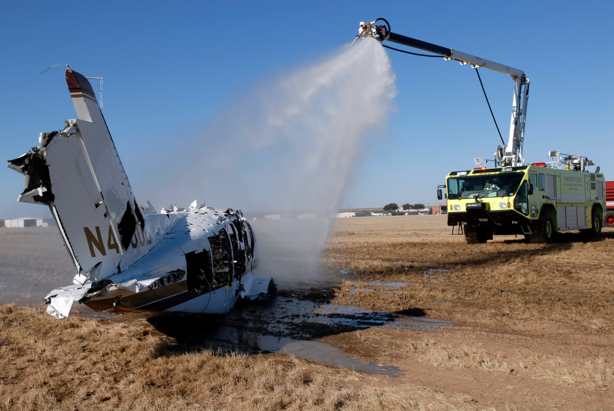 A fire crew from the City of San Angelo Fire Department sprays down aircraft wreckage during Exercise Scarlet Hawk 08-02, a joint disaster-preparedness exercise designed to prepare Goodfellow Air Force Base and the City of San Angelo to respond to a crash during the upcoming airshow. Air Fiesta ‘08, a joint endeavor by Goodfellow Air Force Base and the City of San Angelo, is set for March 15 at San Angelo Regional Airport / Mathis Field. (U.S. Air Force photo by Senior Airman Kamaile Chan)