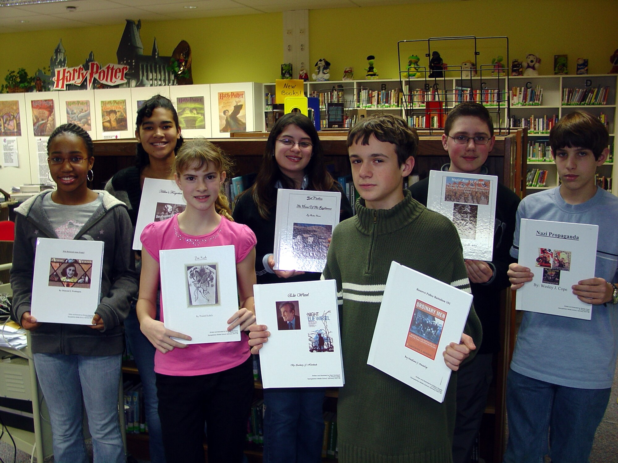 SPANGDAHLEM AIR BASE, Germany -- Students from Spangdahlem Middle School’s seventh and eighth grade gifted education class display books they created while learning about World War II in Europe. The student’s study included a chronological look at the rise of the Nazi party, appointment of Adolf Hitler as Chancellor of Germany, the D Day landings and liberation of the death camps throughout Europe. Each student chose and researched a Holocaust topic and the information they learned was published in hardback book form, which can be viewed at the Spangdahlem Base library.  (Courtesy photo)