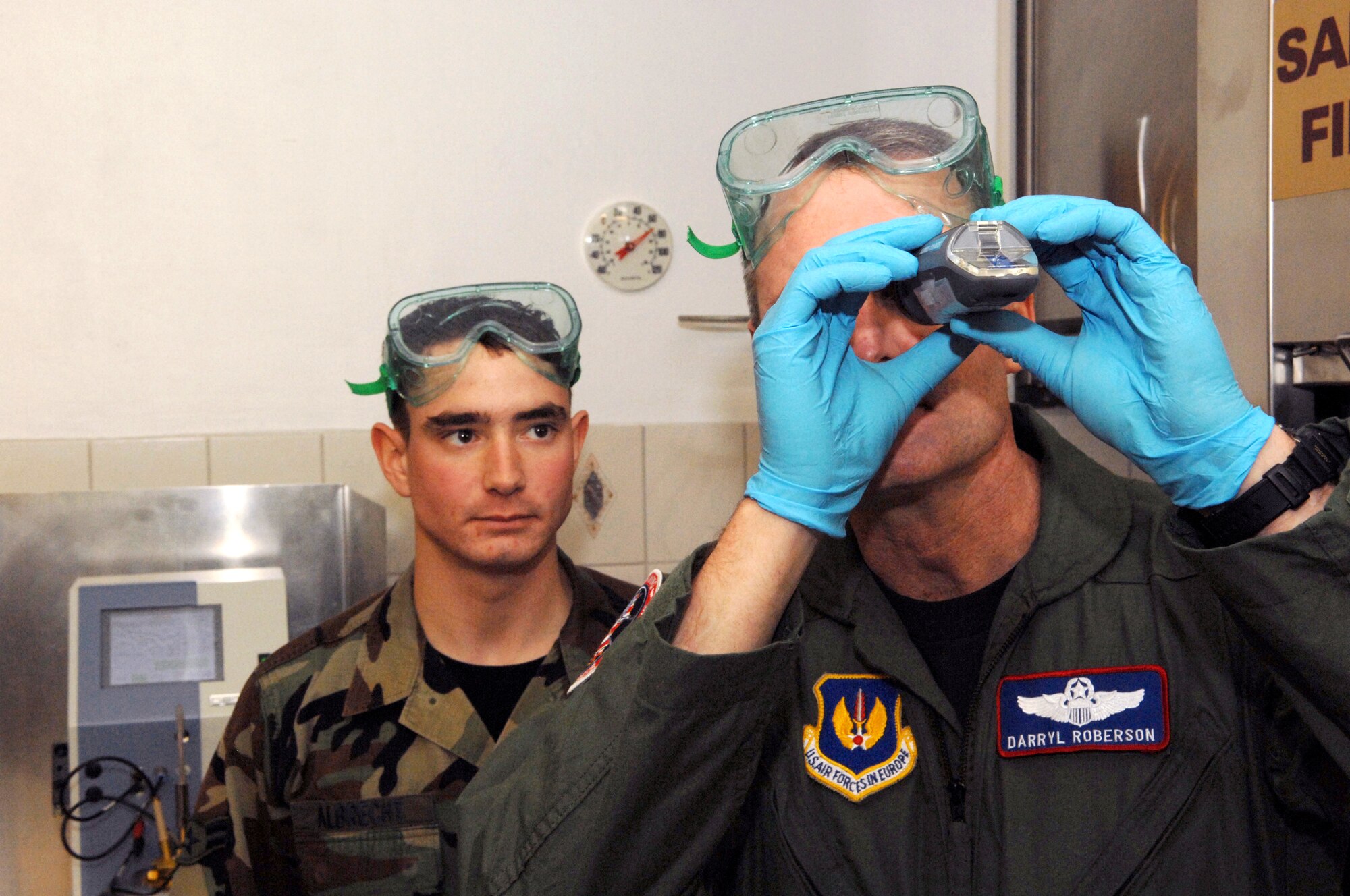 SPANGDAHLEM AIR BASE, Germany – Col. Darryl Roberson, 52nd Fighter Wing commander, examines a refractometer as Airman 1st Class Darren J. Albrecht, 52nd Logistics Readiness Squadron looks on. Colonel Roberson spent a few hours learning about fuel operations from Airman Albrecht Feb. 19. Airman Albrecht, a fuels lab technician, is a native of Midwest City, Okla. (U.S. Air Force photo/Senior Airman Logan Tuttle)