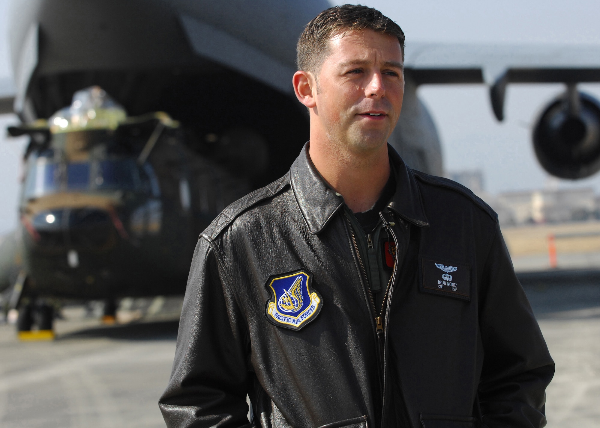 YOKOTA AIR BASE, Japan -- U.S. Air Force Capt. Brian Moritz, a C-17 aircraft commander and pilot assigned to the 535th Airlift Squadron at Hickam Air Force Base, Hawaii, gives an interview about the loading of a Japan Ground Self Defense Force CH-47J Chinook helicopter into U.S. Air Force C-17 Globemaster III cargo plane Feb. 23. It was the first time a Japanese helicopter has been loaded into the aircraft of another nation. The demonstration was conducted the last morning of the Pacific Global Air Mobility Seminar held Feb. 22 and 23. The CH-47J is assigned to the 1st Helicopter Brigade at JGSDF Camp Kisarazu in Kisarazu City, Chiba Prefecture, and the C-17 is assigned to the 535th Airlift Squadron. (U.S. Air Force photo by Osakabe Yasuo)