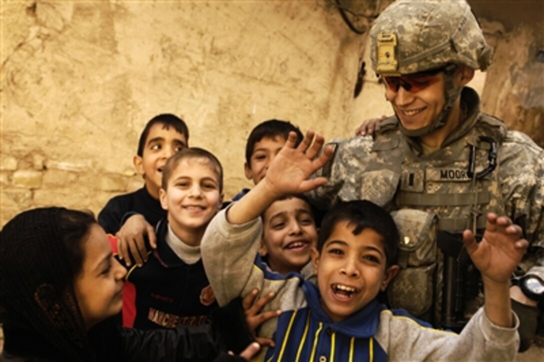 U.S. Army 1st Lt. Michael Moore is surrounded by Iraqi children during a patrol the Rusafa neighborhood of Baghdad, Iraq, on Feb. 17, 2008.  Moore is a platoon leader with 3rd Platoon, Charlie Company, 1st Battalion, 504th Parachute Infantry Regiment. 