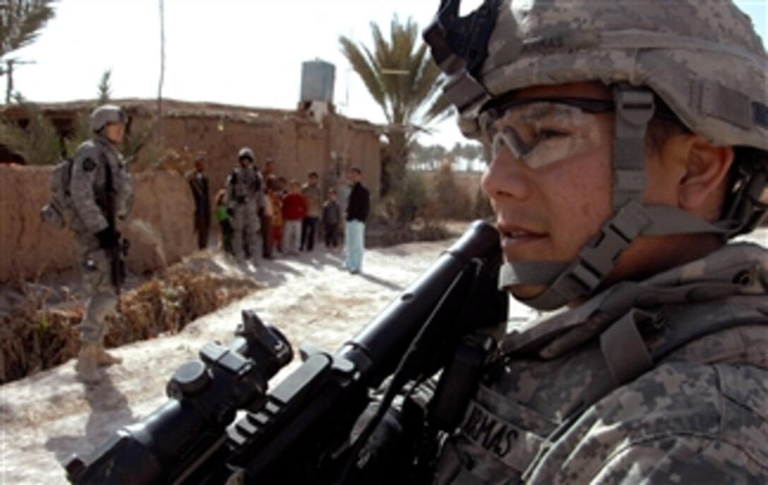 A U.S. soldier, along with Iraqi police, clears and patrols the town of Aswad in the Diyala province of Iraq, Feb. 19, 2008.