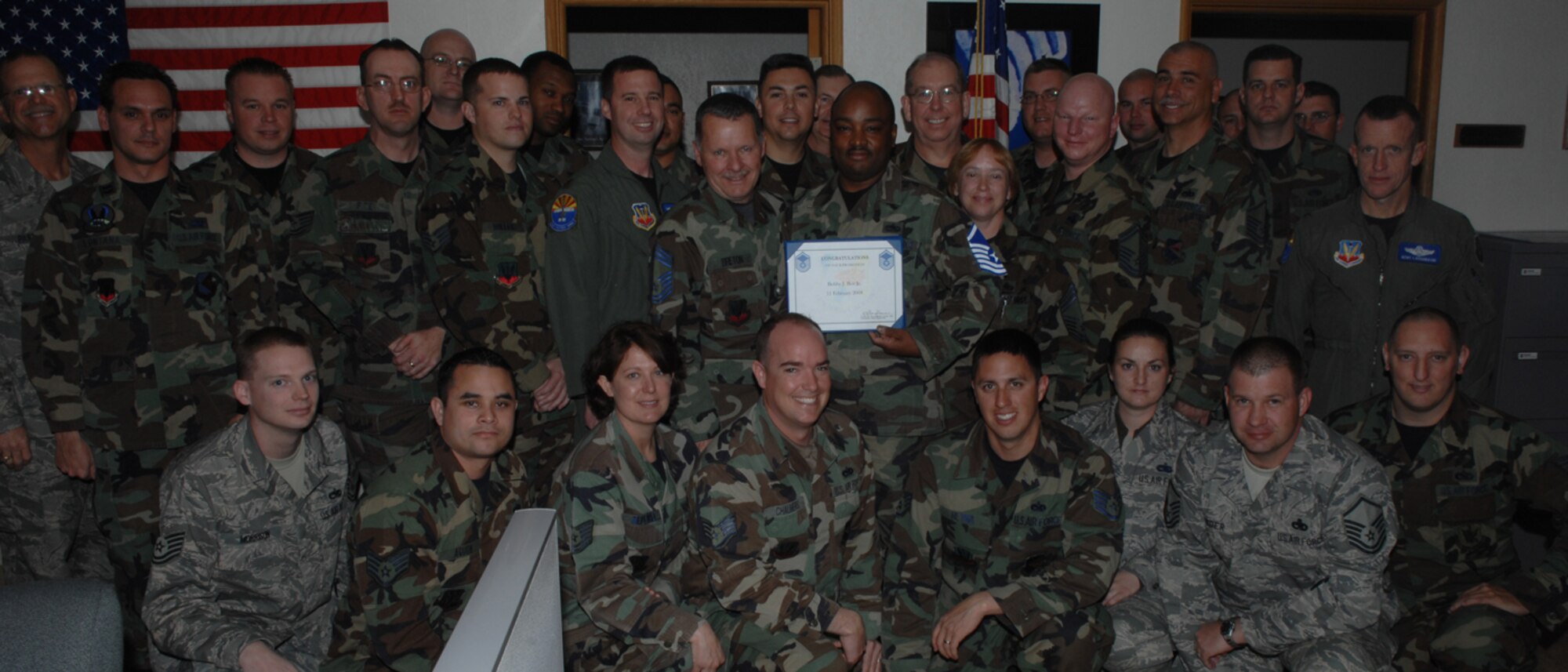 Tech. Sgt. Bobby Box poses for a photo with Col. Kent Laughbaum, 355th Fighter Wing commander, Chief Master Sgt. James Parkhill, 355th Fighter Wing command chief, and his fellow Airmen Feb 11, as he found out he got STEP promoted from technical sergeant to master sergeant. (U.S. Air Force Senior Airman Christina Kinsey)