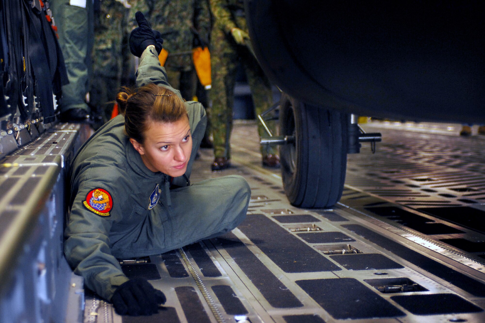 Senior Airman Lisa Long directs the loading of a Japan Ground Self Defense Force CH-47J Chinook onto a C-17 Globemaster III cargo plane Feb. 23 at Yokota Air Base, Japan. The demonstration was conducted during the Pacific Global Air Mobility Seminar held Feb. 22 and 23. The CH-47J is assigned to the 1st Helicopter Brigade at JGSDF Camp Kisarazu in Kisarazu City, Chiba Prefecture. Airman Long is a loadmaster assigned to the 535th Airlift Squadron at Hickam Air Force Base, Hawaii. The C-17 is also assigned to the 535th Airlift Squadron. (U.S. Air Force photo/Osakabe Yasuo) 
