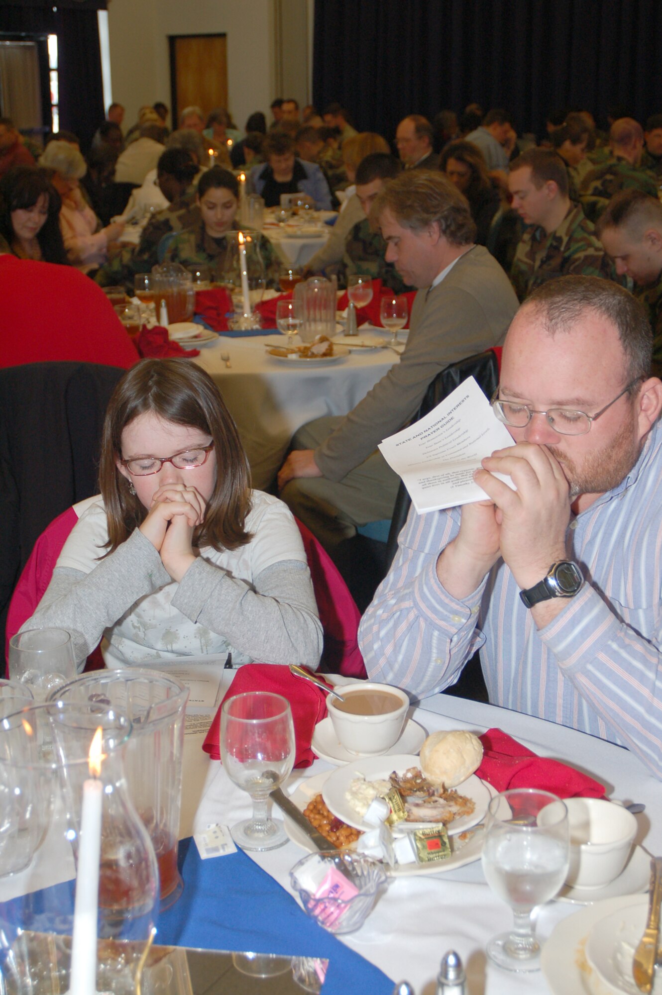 Retired Master Sgt. Jerald Buckley, 436th Aircraft Maintenance Squadron, and his daughter Sara, 10, bow their heads in prayer at the National Prayer Luncheon Feb. 26 at Dover Air Force Base. The luncheon was attended by more than 200 active duty, Reserve, DoD employees and civilian guests, and it brought together people to recognize the moral and spiritual values upon which the nation was founded. (U.S. Air Force photo/Master Sgt. Melissa Phillips)
