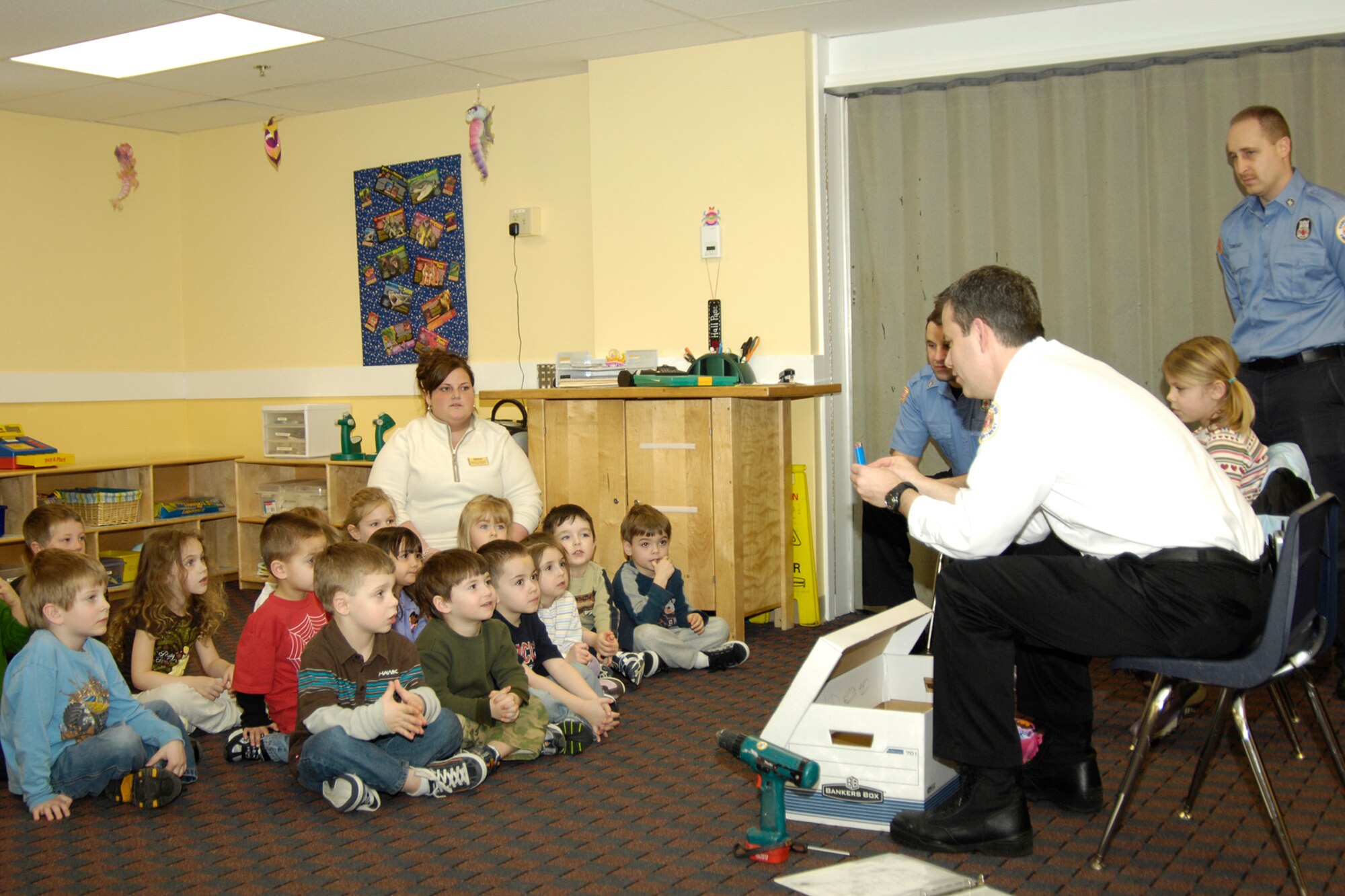 HANSCOM AFB, Mass. – Students in the Hanscom School Age Program take part in an interactive “tools or toys” exercise with Robert Coonce, Hanscom Fire Prevention Services and assistant fire chief, and other members of the Hanscom Fire Department. The exercise was designed to teach children not to play with fire and was part of the new Hanscom Juvenile Fire Setters program that the Fire Department unveiled Feb. 26. (U.S. Air Force photo by Linda LaBonte Britt)


