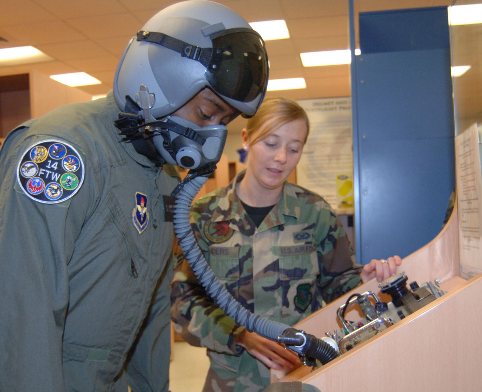 Airman 1st Class Natasha Sanders, 41st Flying Training Squadron, helps Tech. Sgt. Anthony Fleming, 332nd Recruiting Squadron, check the pressure in his mask before his T-6 flight Tuesday. (U.S. Air Force photo by Airman 1st Class Danielle Hill)