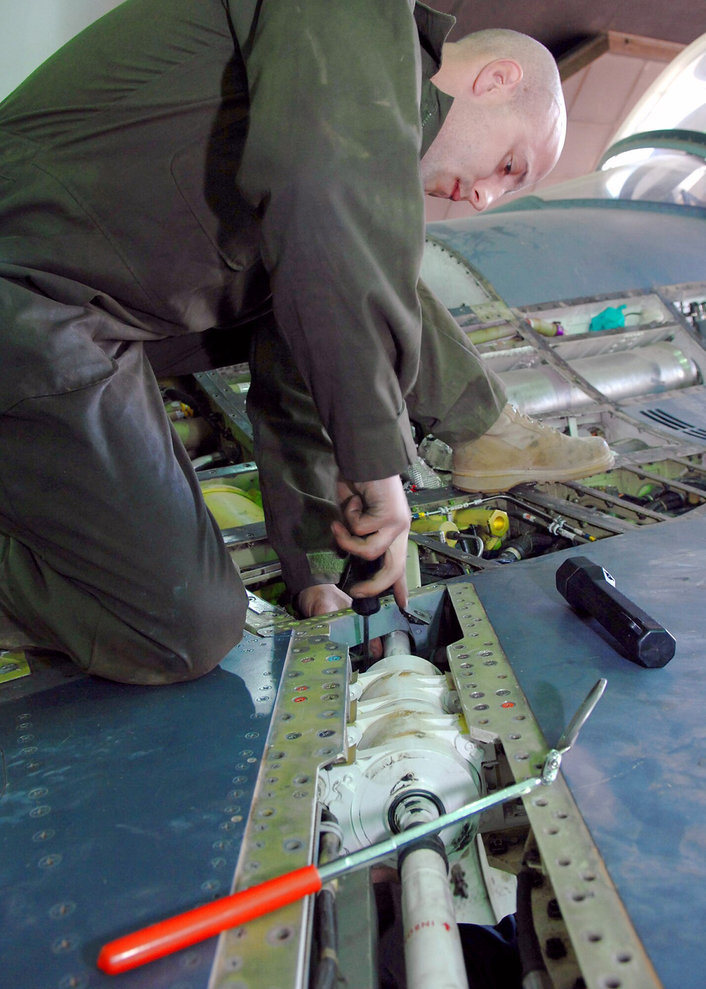 Tech. Sgt. Robert Fredenberg installs and repositions a clamp to prevent electrical wires from fraying and causing the right leading edge flap malfunctions on an F-16 Fighting Falcon Feb. 22 at Balad Air Base, Iraq. The flaps on the leading edge of the wings of an F-16 assist aircraft movement during slower air speeds. Sergeant Fredenberg is a 332nd Expeditionary Maintenance Squadron crew chief deployed from the Wisconsin National Guard. (U.S. Air Force photo/Senior Airman Julianne Showalter) 