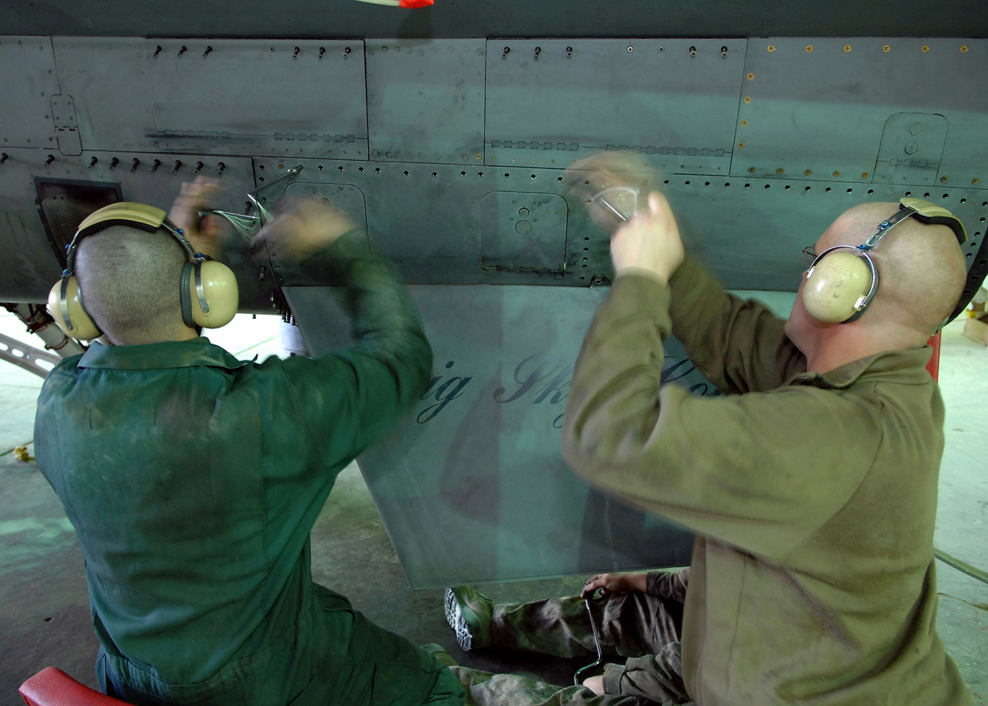 Senior Airmen Adam Fink and Christopher Jaeger unscrew the left ventral fin of an F-16 Fighting Falcon Feb. 22 at Balad Air Base, Iraq. During a phase inspection, all panels and covers are taken off of the aircraft for preventative maintenance on the aircraft systems and equipment. The aircraft crews fly missions in support of Operation Iraqi Freedom. Both Airmen are 332nd Expeditionary Maintenance Squadron crew chiefs deployed from the Wisconsin National Guard. (U.S. Air Force photo/Senior Airman Julianne Showalter) 