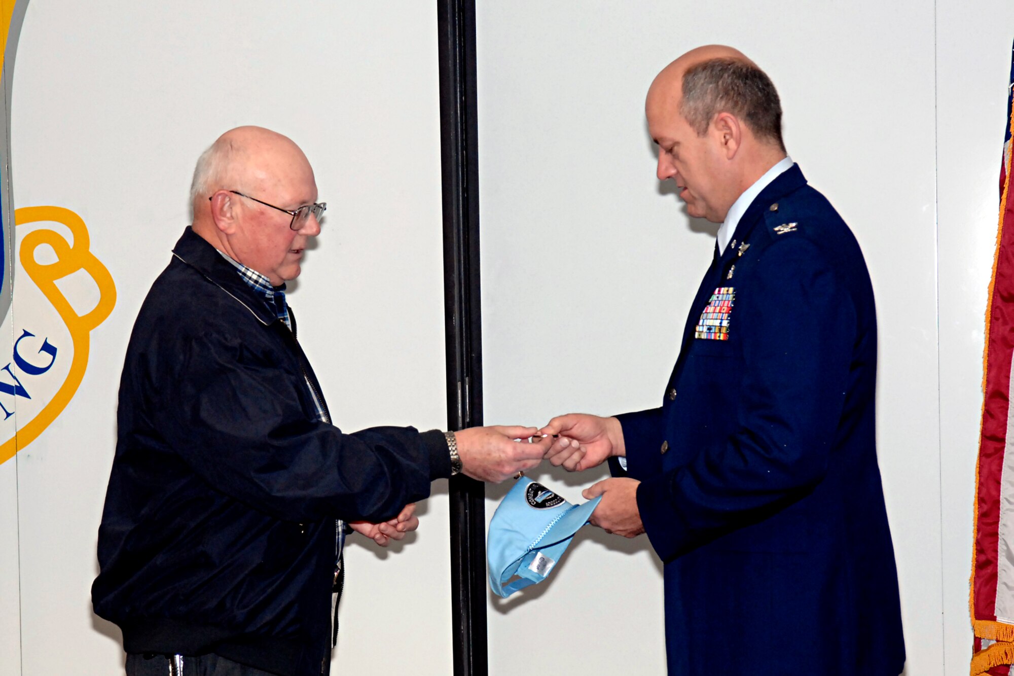 Ray Yamrus (left), National Commander of the Combat Infantry Badge Association and 43rd Aeromedical Evacuation Squadron Honorary Commander, presents his national commander coin to Col. Robert Marks, 43rd AES Commander, during the unit’s commander’s call Feb. 21. Mr. Yamrus also presented Colonel Marks with a CIB Association hat, and received the 43rd AES coin and hat in return. Honorary Commanders are civic leaders who are invited to participate in unit functions so they learn more about Team Pope and help pass that information along to others in the local community. (U.S. Air Force Photo by Mike Murchison)
