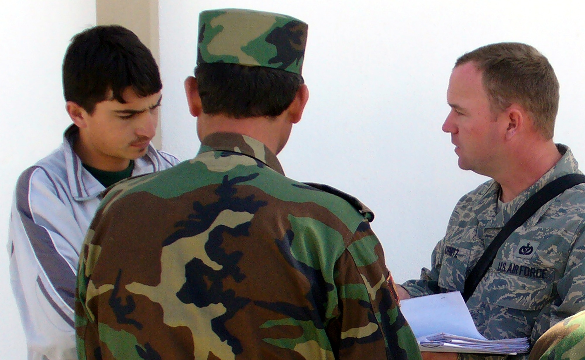 Tech. Sgt. Samuel Schmitz (right), contingency skills instructor from the U.S. Air Force Expeditionary Center's 421st Combat Training Squadron at Fort Dix, N.J., talks with an Afghan National Army soldier through an interpreter in a village near Kabul, Afghanistan, Sept. 29, 2007 during his deployment there.  Sergeant Schmitz, an Air Force civil engineering power production specialist, deployed as an Afghan National Army Central Movement Agency Mentor from January 2007 to February 2008.  (U.S. Air Force Photo)