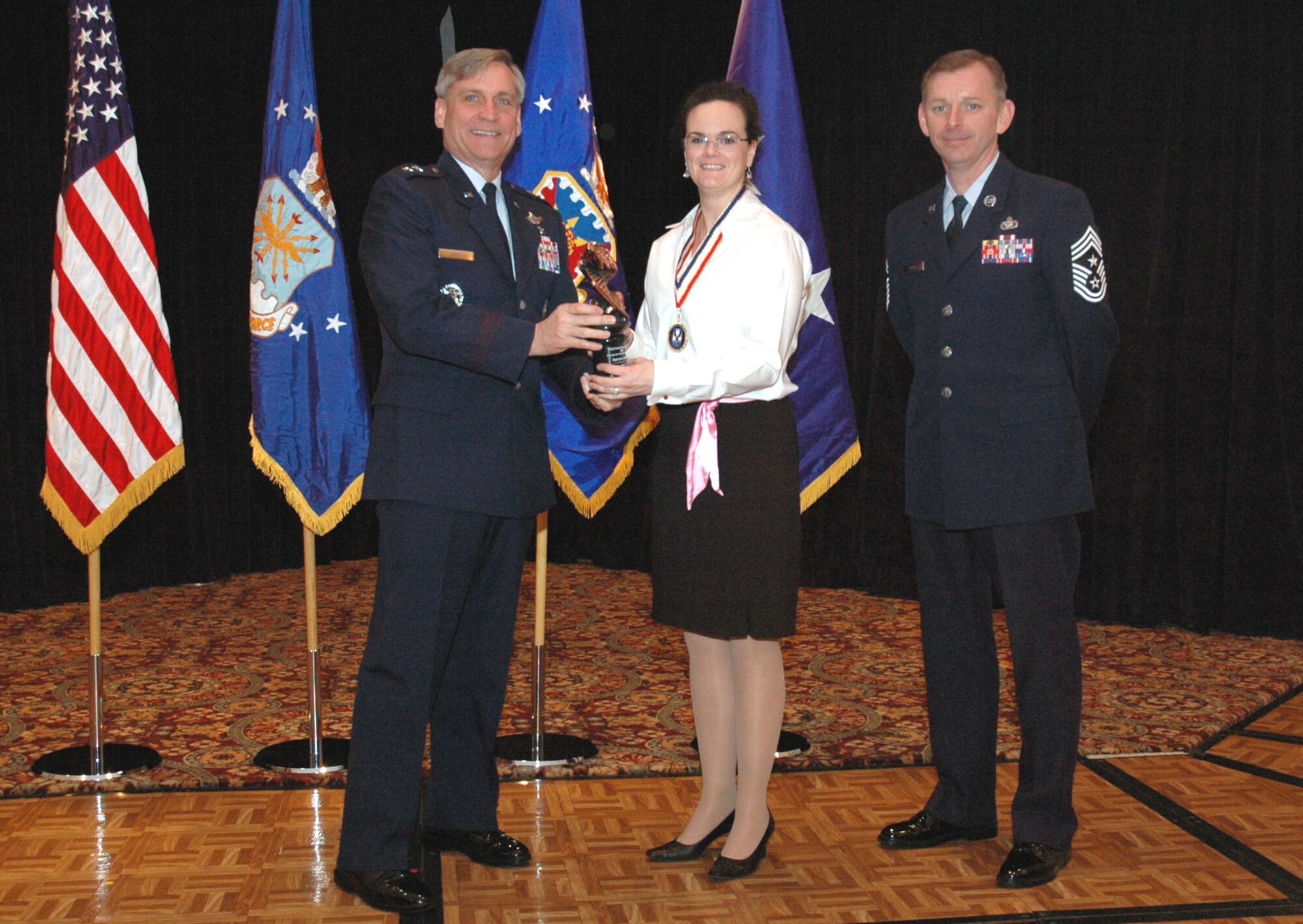 Maj. Gen. Kip Self, U.S. Air Force Expeditionary Center commander, presents Mrs. Kristen Nalette, Mobility Operations School, with the USAF EC Category I Civilian of the Year Award for 2007 during the Center's annual awards luncheon Feb. 22, 2008, in the McGuire Air Force Base, N.J., Club.  Chief Master Sgt. Jeffry Helm, USAF EC command chief, was also on hand for the presentation.  (U.S. Air Force Photo/Tech. Sgt. Scott T. Sturkol)