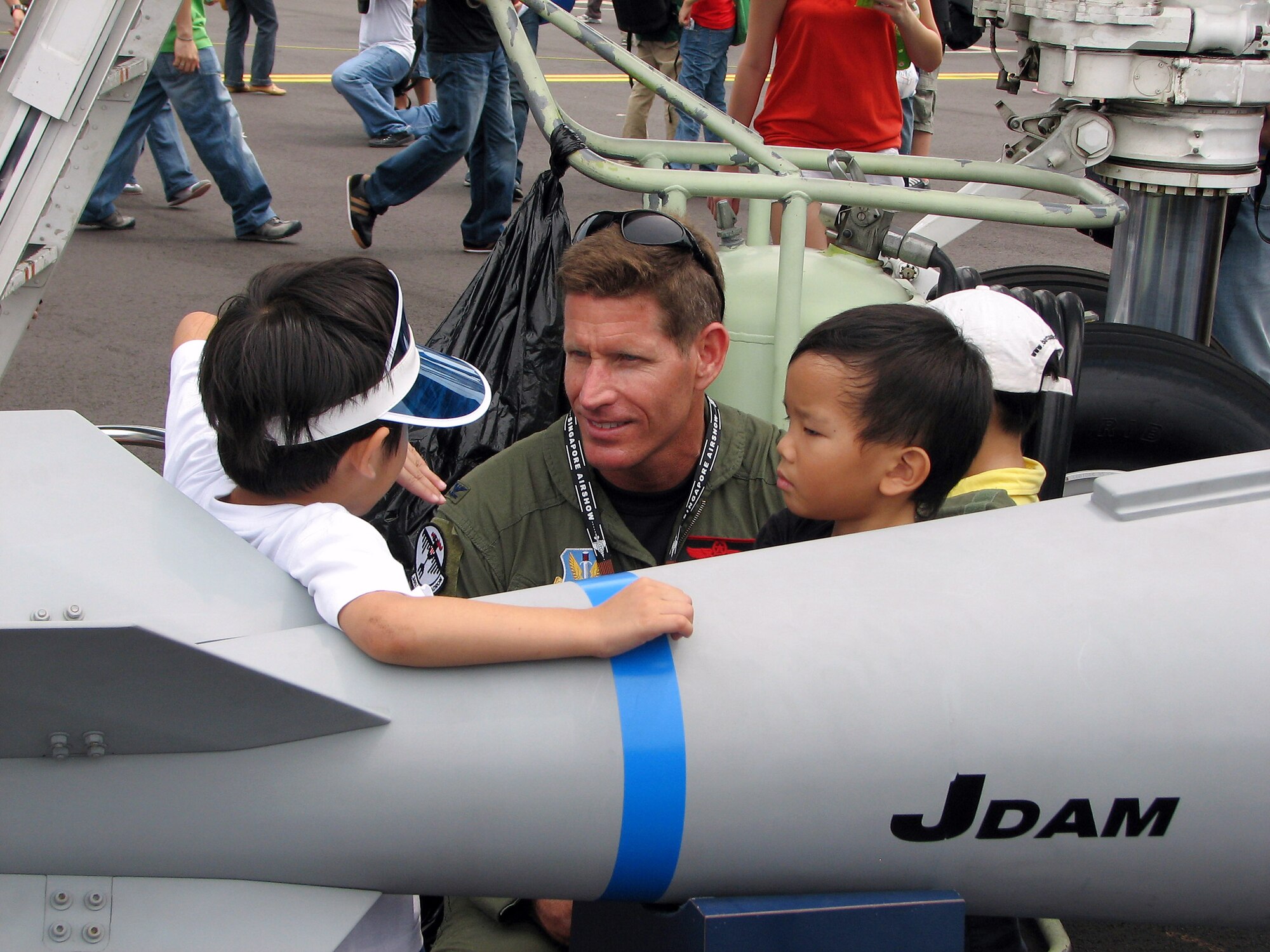 Col. Pete Castor speaks with children during a public day at the Singapore Air Show Feb. 23. The 28th Bomb Wing at Ellsworth Air Force Base, S.D., provided a B-1B Lancer for static display and aircrews flew the bomber nonstop from Ellsworth AFB to Singapore. Colonel Castor is the vice commander of the 28th Bomb Wing. (U.S. Air Force photo/Senior Master Sgt. Charles Ramey) 