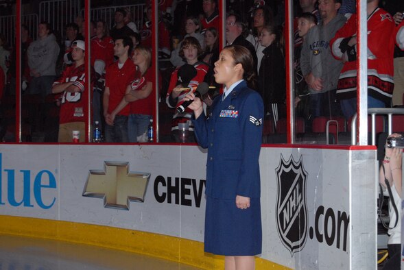 Senior Airman Marivic Len-Marin, 43rd Airlift Wing Protocol Office, sings the National Anthem prior to the Carolina Hurricanes Military Appreciation Night game against the Washington Capitals Feb. 23 in Raleigh, N.C. Pope received 250 tickets for the NHL game at the RBC Center. (U.S. Air Force Photo by 2nd Lt. Chris Hoyler)
