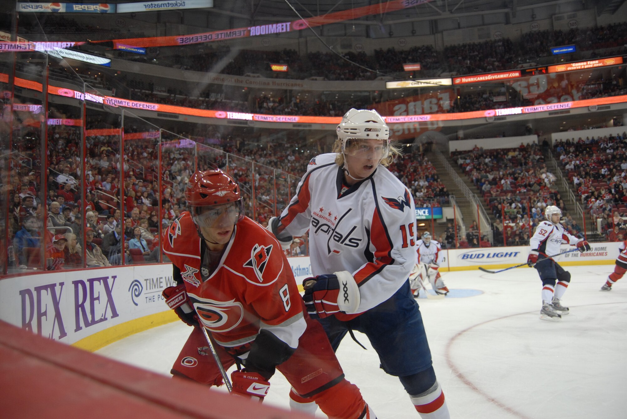 Matt Cullen (8) and Nicklas Backstrom (19) battle in the corner for the puck during Military Appreciation Night at the National Hockey League game between the Carolina Hurricanes and Washington Capitals Feb. 23 in Raleigh, N.C.. Pope received 250 tickets for the event. (U.S. Air Force Photo by 2nd Lt. Chris Hoyler)