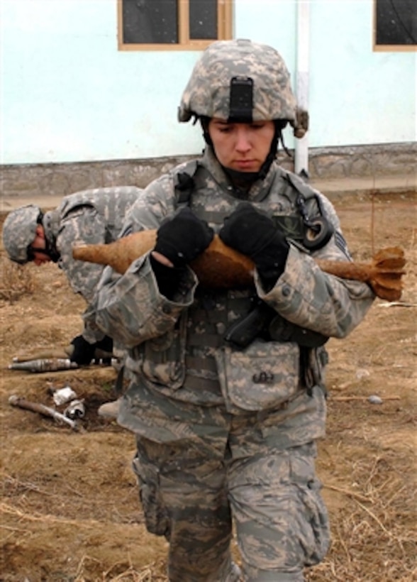U.S. Air Force Senior Airman Sarah Burrill carries unexploded ordnance to load onto a joint explosive ordnance rapid response vehicle in Afghanistan on Feb. 2, 2008.  Burrill is a member of the explosive ordnance disposal team that is removing and destroying unexploded ordnance gathered by the Kohistan II Afghan National Police.  