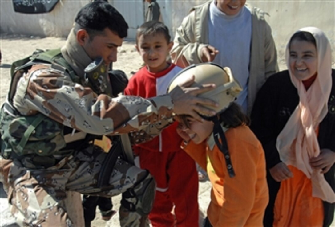 An Iraqi Security Force member plays with local children at the al Durrer School in the Shifta Village, Diyala Province, Iraq, Feb. 22, 2008.