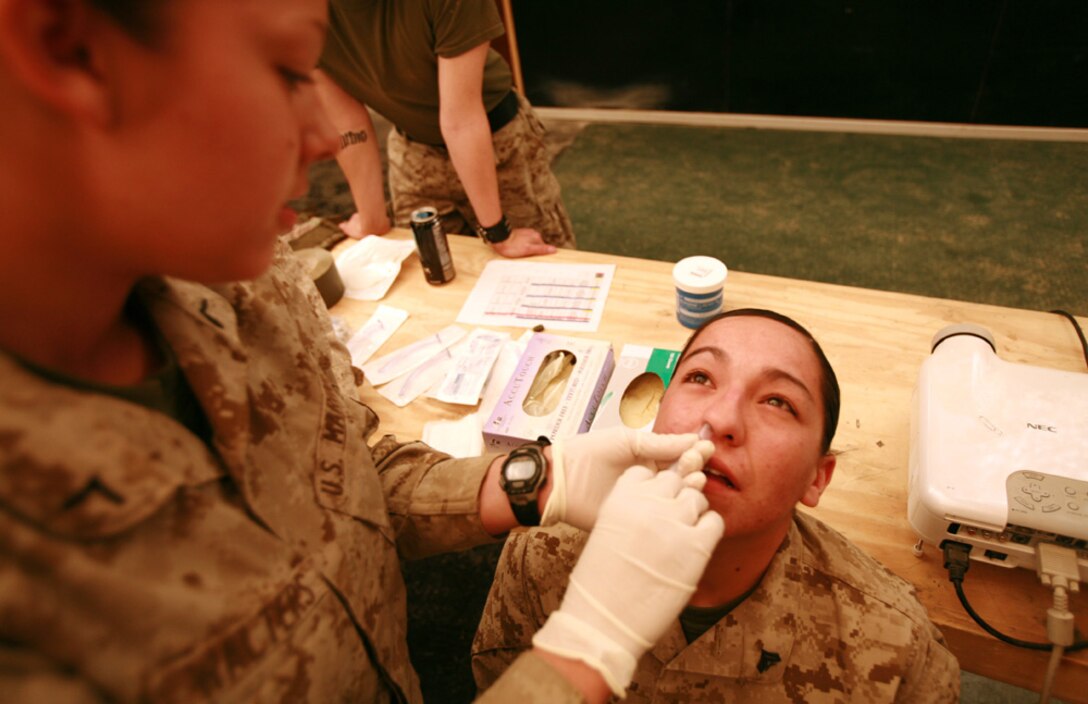 Private First Class Mary H. Walters, a 19-year-old field wireman from Blackfoot, Idaho, inserts a tube inside the nose of Cpl. Monica S. Mendoza, 20 from El Paso, Texas,  a Chemical Biological Radiological and Nuclear defense specialist during a Combat Life Saver class during Lioness training.