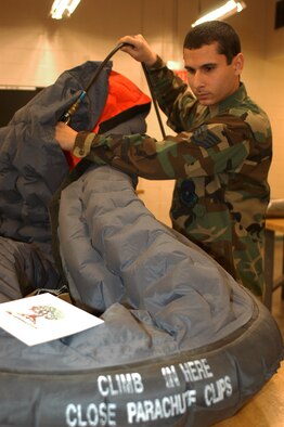 One of the things Staff Sgt. Travis Roman, 301st Fighter Wing aircrew flight equipment section, does during his shift is checks the quality of the equipment, the other is practicing his beat box skills -- a talent he acquired out of boredom. (U.S. Air Force Photo/Tech. Sgt. Stephen Bailey)                                