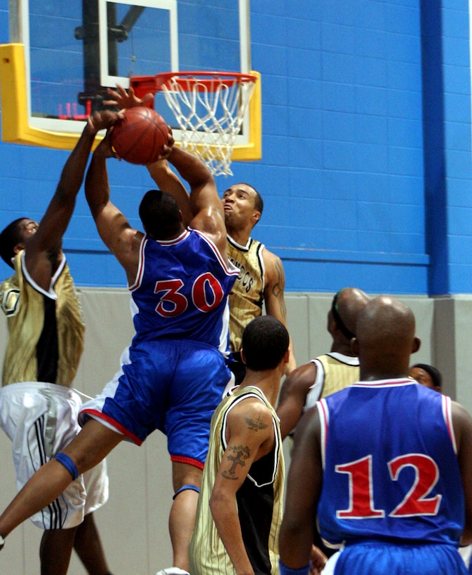 Mario Webb and Alfonso Porter (gold), Hurlburt Field, Fla., converge on Dewayne Huff, Robins Air Force Base, Ga., Dec. 10.  The Hurlburt Field Commandos defeated Robins 85-83.  (Air Force photo by Staff Sgt. Mareshah Haynes) 