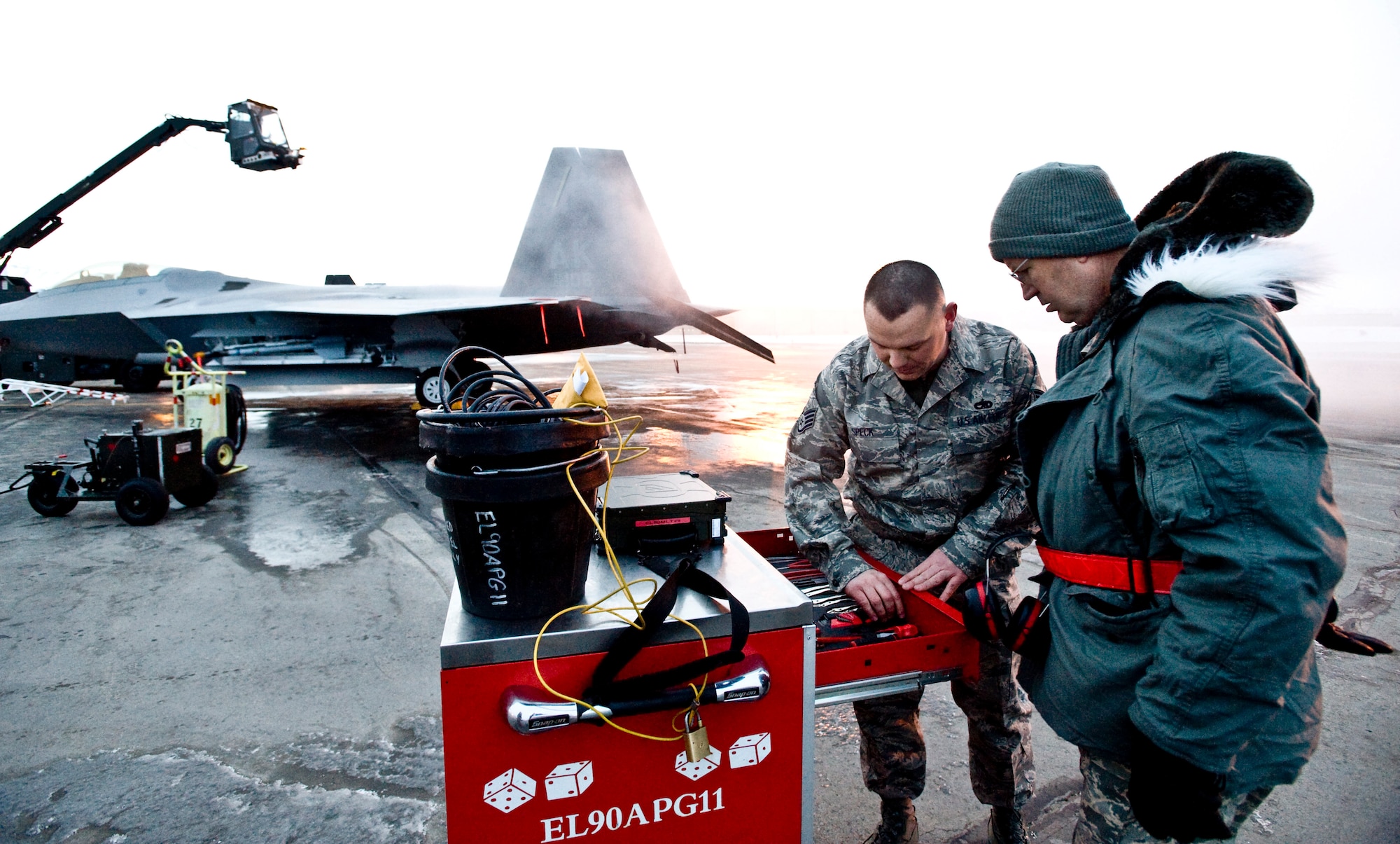 ELMENDORF AIR FORCE BASE, Alaska -- Staff Sgt. Justin Speck, a crew chief for 90th Aircraft Maintenance Unit, shows Maj. Gen. Jeffrey Riemer, the Air Force F-22 Program executive officer, the tools of the trade here Feb. 27. General Riemer is here to see how the F-22 handles in extreme weather conditions and how its maintainers handle the aircraft during the weather. (U.S. Air Force photo by Airman 1st Class Jonathan Steffen)