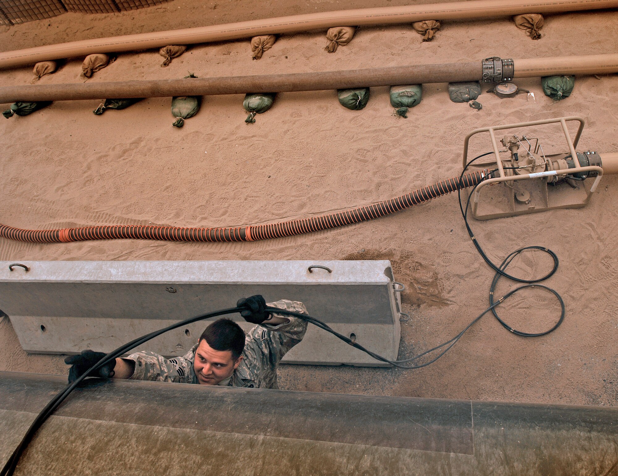 Senior Airman Bryan Gallagher prepares to pump fuel from the ramp bladder storage into an R-11 fuel truck Feb. 26 in Southwest Asia. The fuels management flight is responsible for inventorying the fuel daily, and the transfer and issue of fuel to both vehicle operators and aircrews in support of operations Enduring Freedom and Iraqi Freedom. Airman Gallagher is a fuels technician from the 386th Expeditionary Logistics Readiness Squadron. (U.S. Air Force photo/Staff Sgt. Patrick Dixon) 