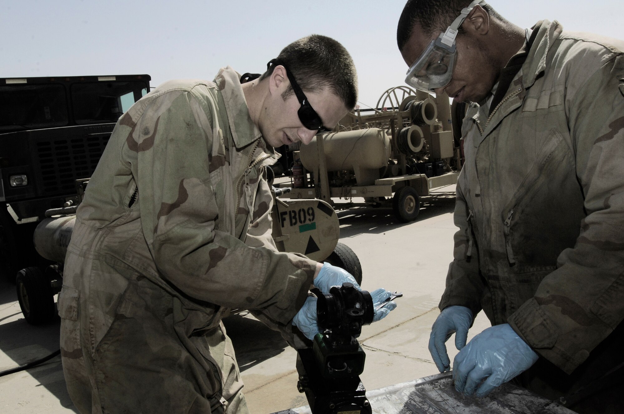 Senior Airmen Brandon Huelsman (left) and  Ben McDonald repair an over-wing valve from an R-11 fuel truck Feb. 27 in Southwest Asia. The fuels management flight is responsible for inventorying fuel daily, and for the transfer and issue of fuel to both vehicle operators and aircrews in support of operations Enduring Freedom and Iraqi Freedom. Both Airmen are refueling maintenance technicians from the 386th Expeditionary Logistics Readiness Squadron. (U.S. Air Force photo/Staff Sgt. Patrick Dixon) 
