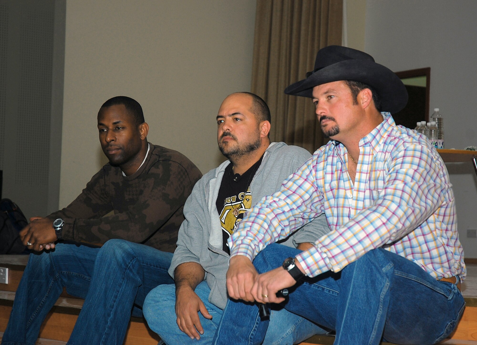 Comedians Danta Jackson (left to right), Bill Dykes, and the cowboy comedian listen to a question during an interview prior to their show Feb. 26 at a Southwest Asia air base. The comedians are on a Multinational Corps Iraq, Army Morale Welfare Recreation, Lone Wolf Entertainment Comedy Tour 2008, which provides entertainment to deployed troops in support of operations Enduring Freedom and Iraqi Freedom. (U.S. Air Force photo/Staff Sgt. Patrick Dixon) 
